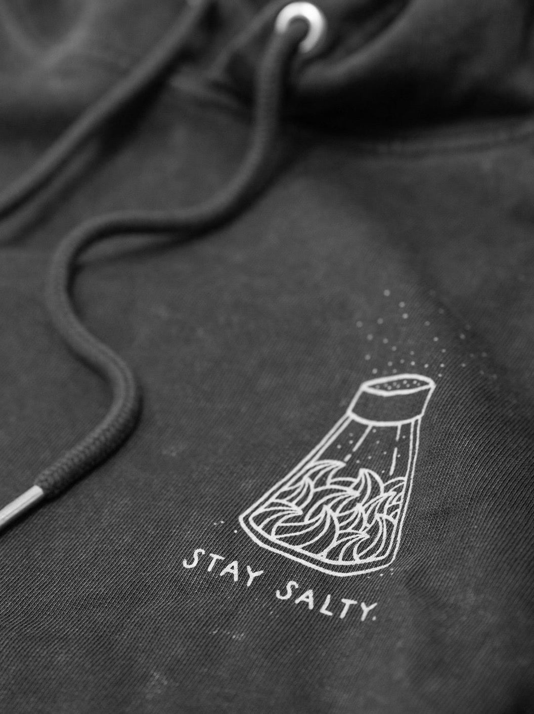 Detailansicht eines Fair Fashion Hoodies von FUXBAU mit einem weiĂen Siebdruck aus 100% Biobaumwolle.
