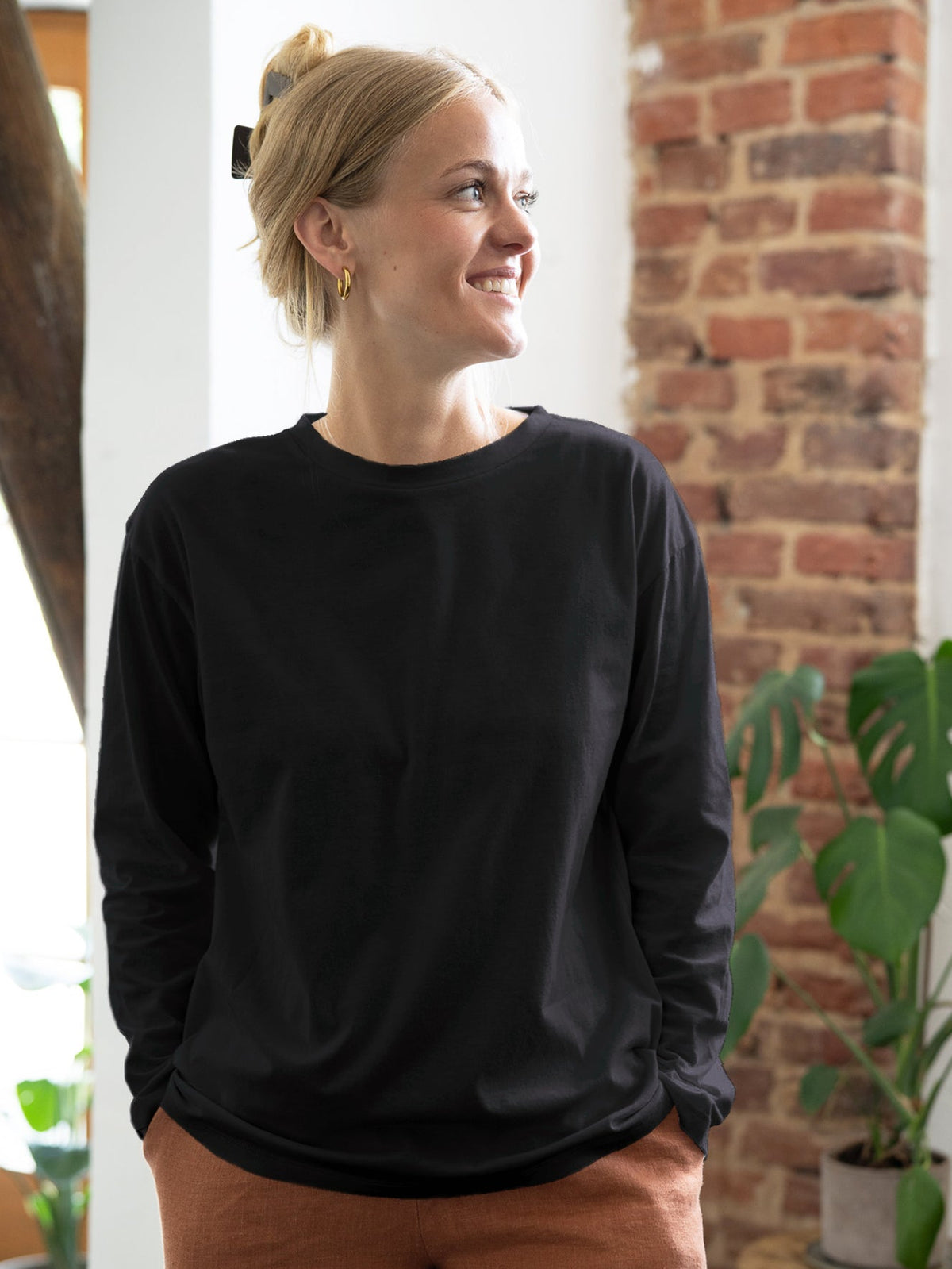 Greta trÀgt das faire Frauen Basic Langarmshirt in schwarz aus 100% GOTS zertifizierter Biobaumwolle made in Portugal
