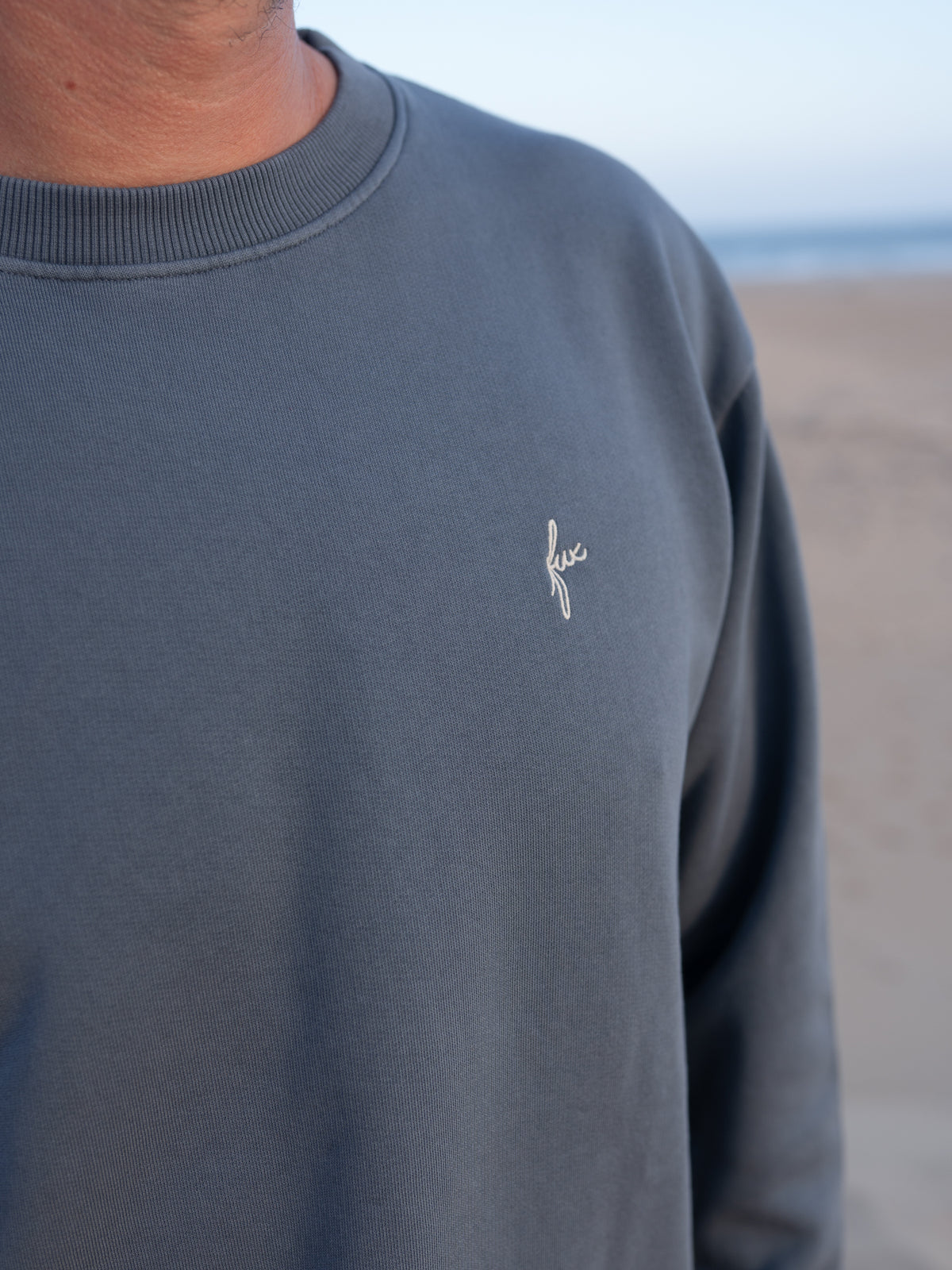 Seeblauer FUXBAU MĂ€nner Pullover im Vintage Look mit dezentem Stick am Strand