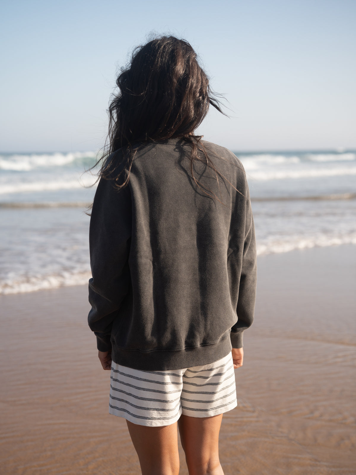 RĂĽckansicht des Frauen Stay Salty Sweaters am Meer