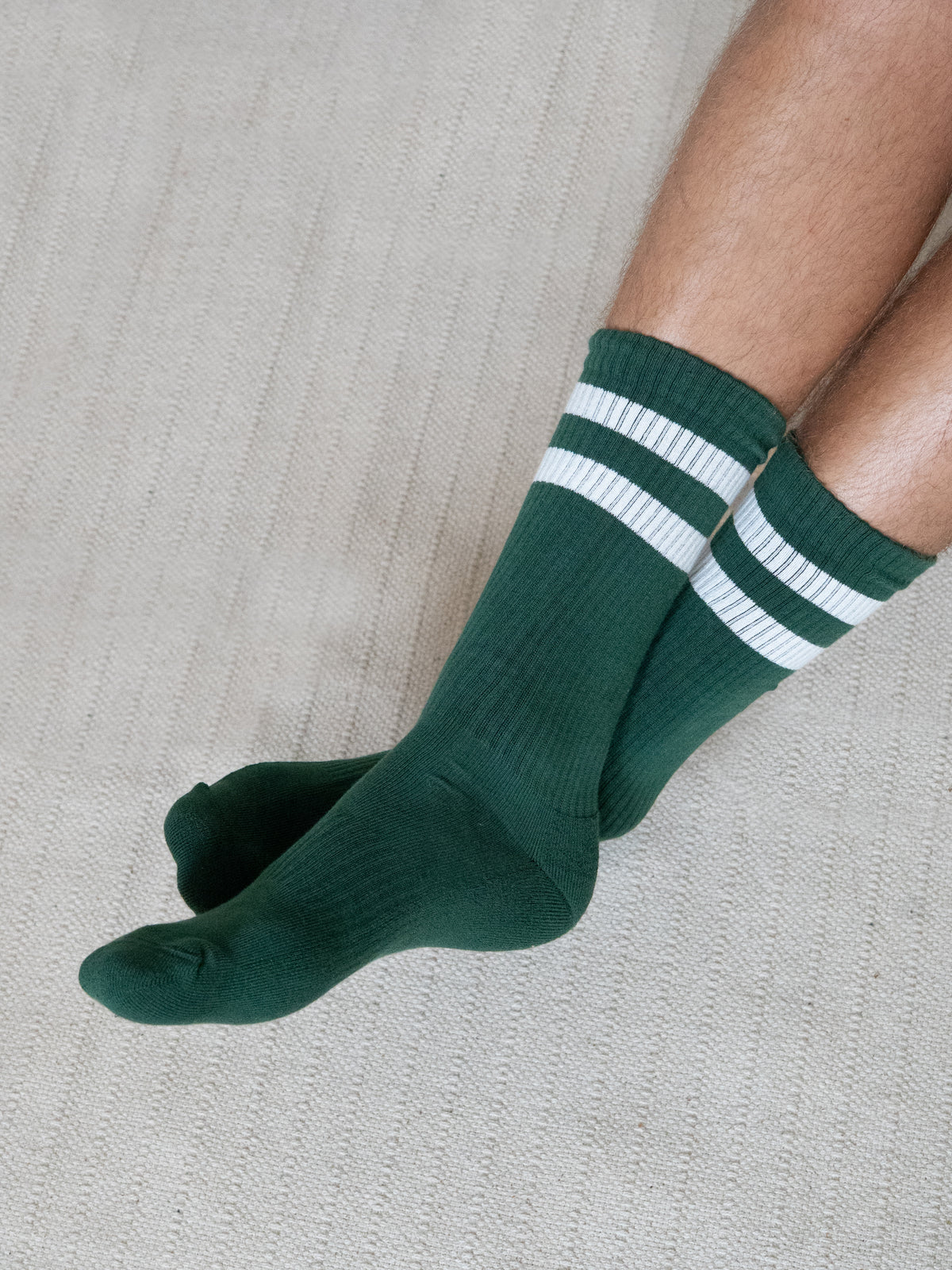 GrĂĽn creme gestreifte Retro Tennissocken aus Biobaumwolle getragen in seitlicher Ansicht
