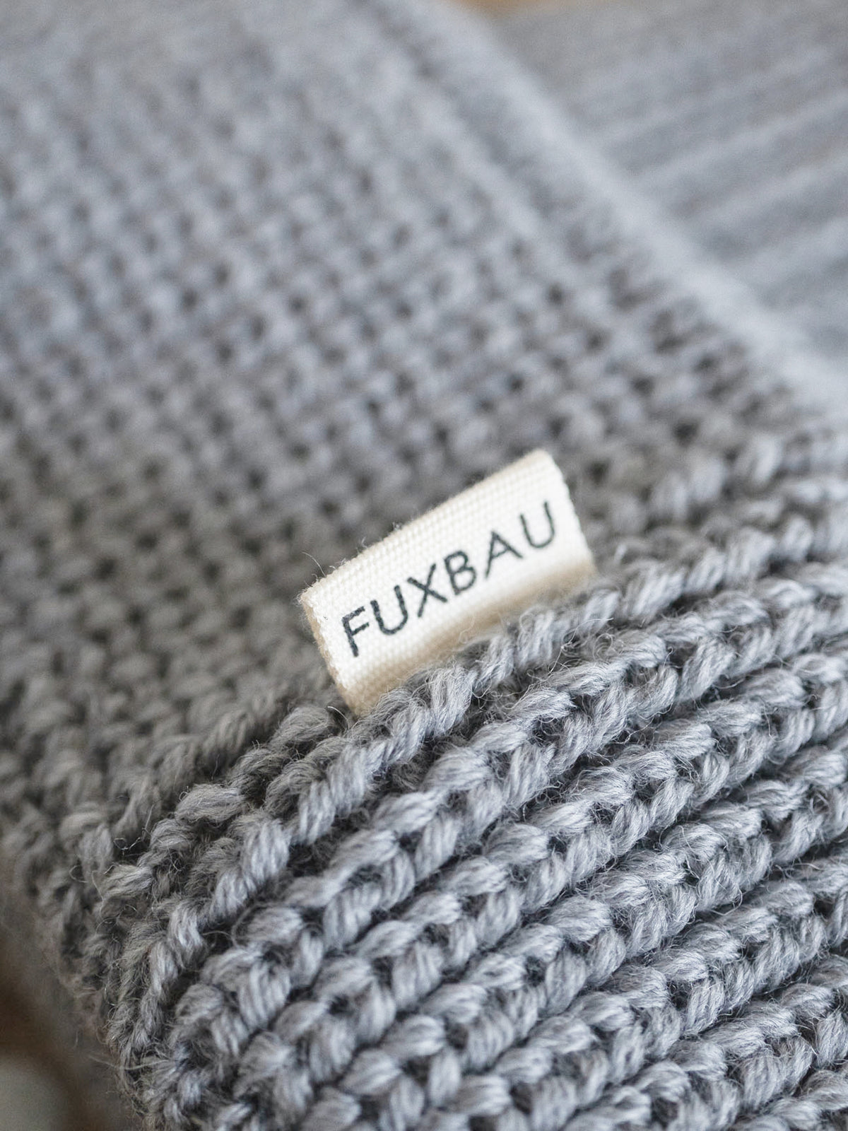 Detailaufnahme der FUXBAU Sideflag der kurzen Merino Fischermütze in graumeliert, GOTS zertifiziert und made in Germany