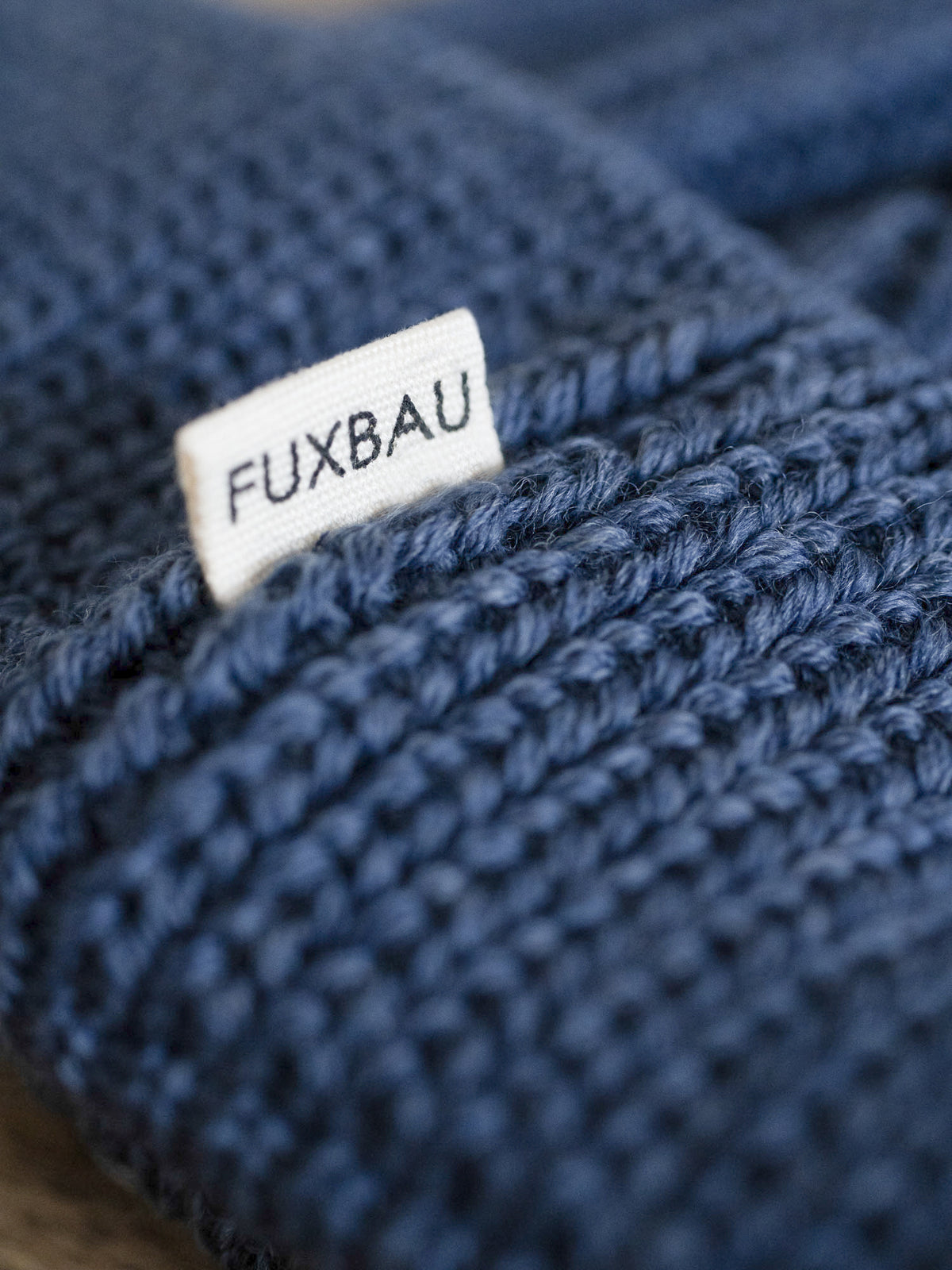 Detailaufnahme der FUXBAU Sideflag der kurzen Merino Fischermütze in nachtblau, GOTS zertifiziert und made in Germany