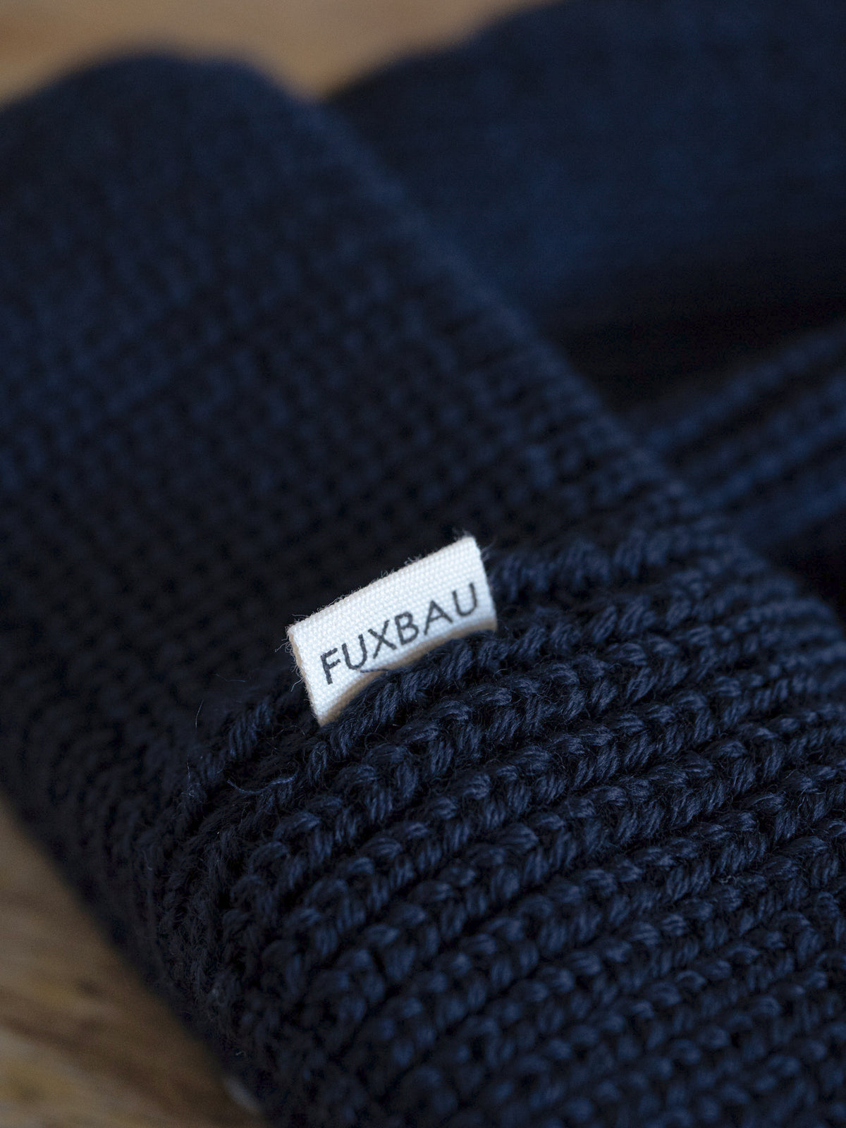 Detailaufnahme der FUXBAU Sideflag der kurzen Merino Fischermütze in navy, GOTS zertifiziert und made in Germany