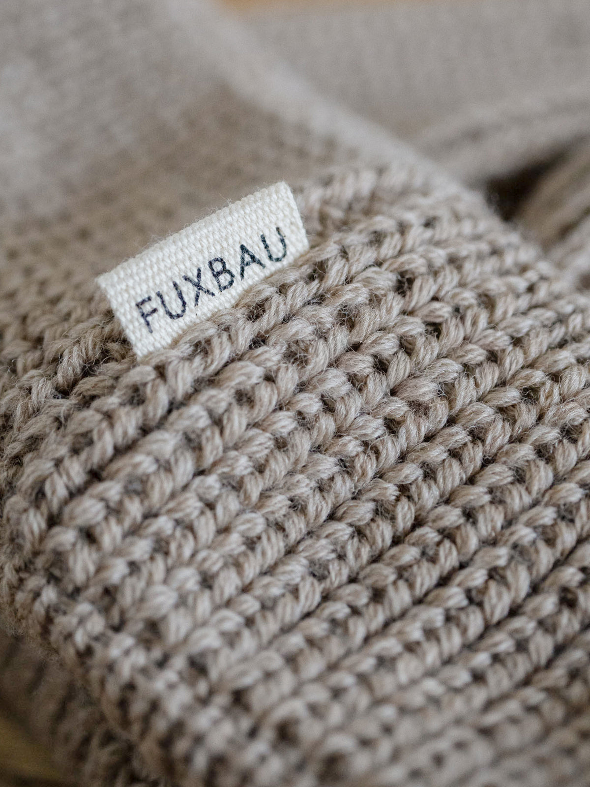 Detailaufnahme der FUXBAU Sideflag der kurzen Merino Fischermütze in sand, GOTS zertifiziert und made in Germany