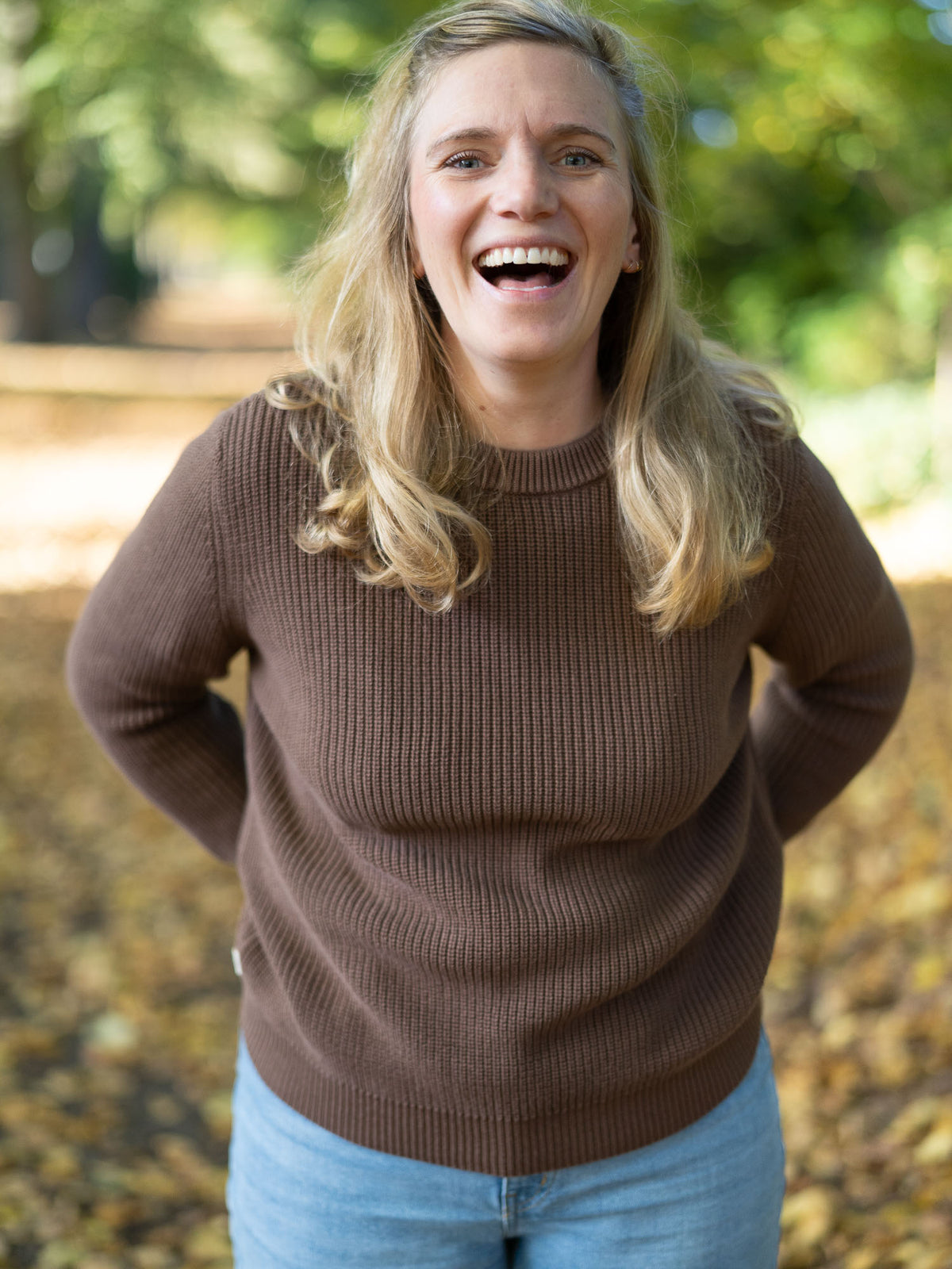 Fair Fashion 4Seasons Strickpullover aus 100% GOTS zertifizierter Biobaumwolle in braun. Getragen von einer jungen blonden Frau im Herbst.