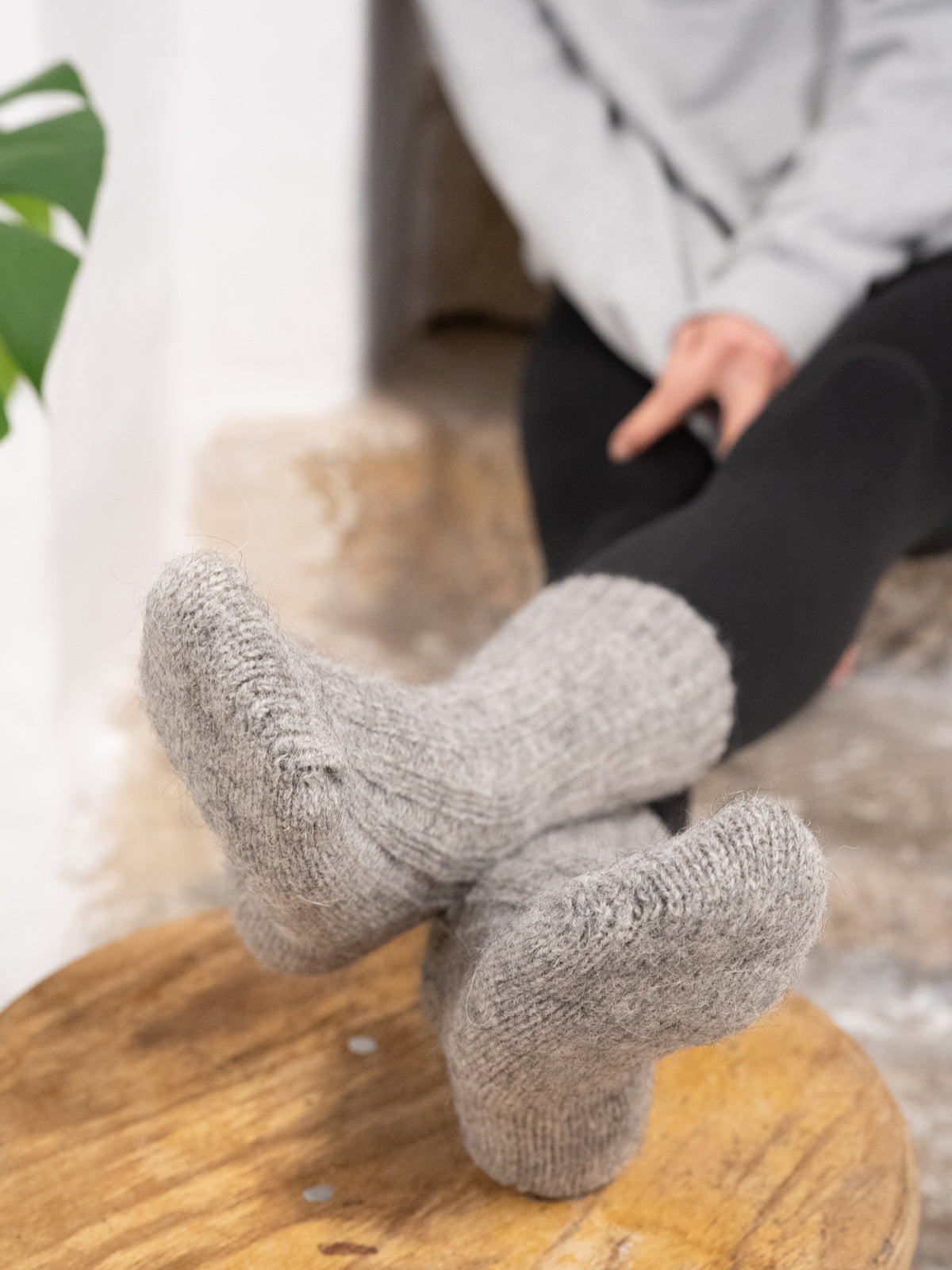 Greta trÀgt unsere warmen und weichen Alpaka Schafwollsocken in grau aus Alpaka und europÀischer Schafwolle.