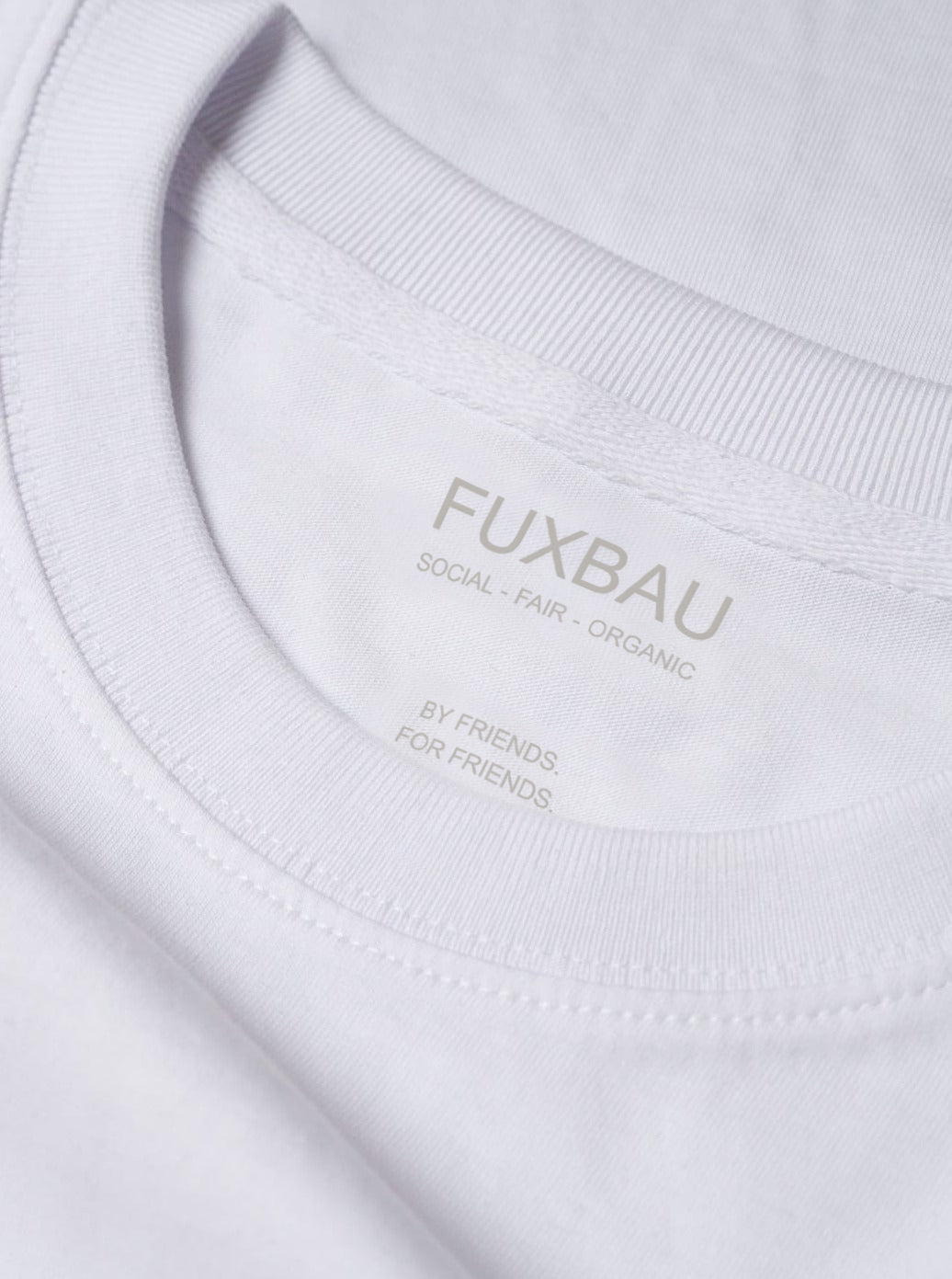 Detailbild eines FUXBAU Männer Basic T-Shirt in weiß mit einem Ton-in-Ton Imprint. Gefertigt aus 100% Biobaumwolle.