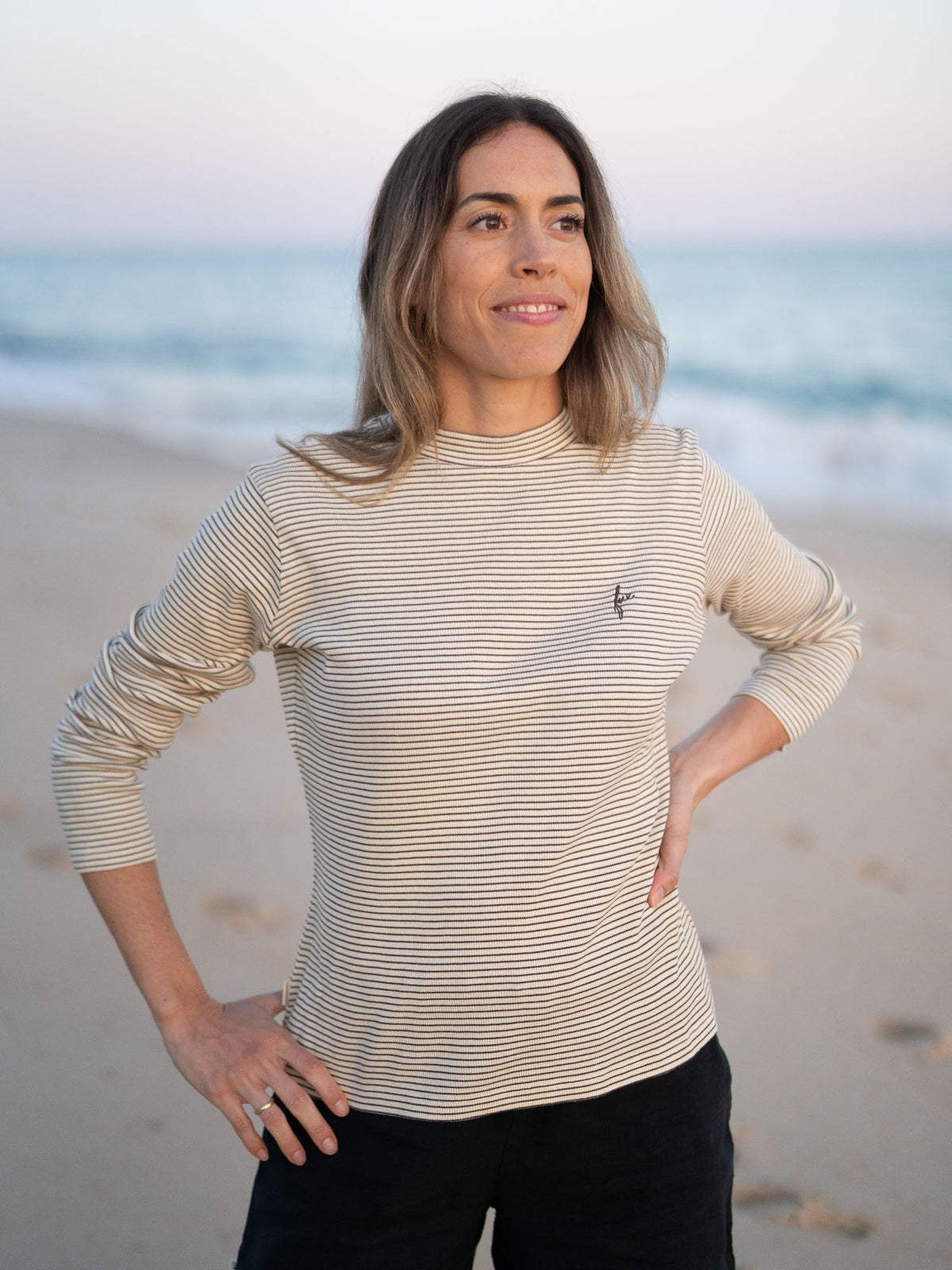 FUXBAU Fair Fashion Fitted Stehkragen Longsleeve creme braun gestreift aus GOTS-zertifizierter Biobaumwolle Made in Portugal getragen am Strand in Portugal.