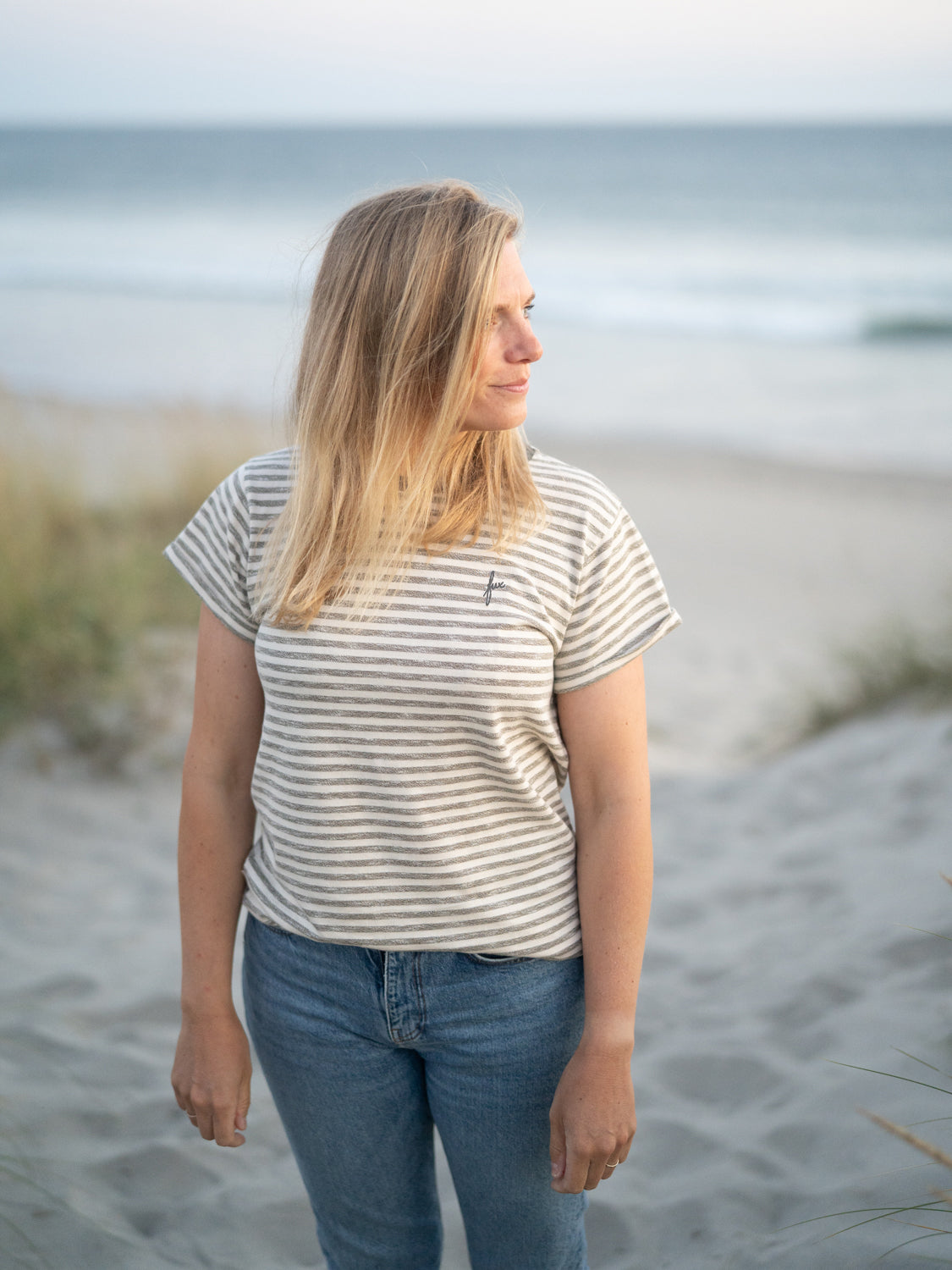 Isi ist 1,68m groĂ und trĂ€gt das Frauen Merida fux T-Shirt in der GröĂe M kombiniert mit einer blauen Jeans.