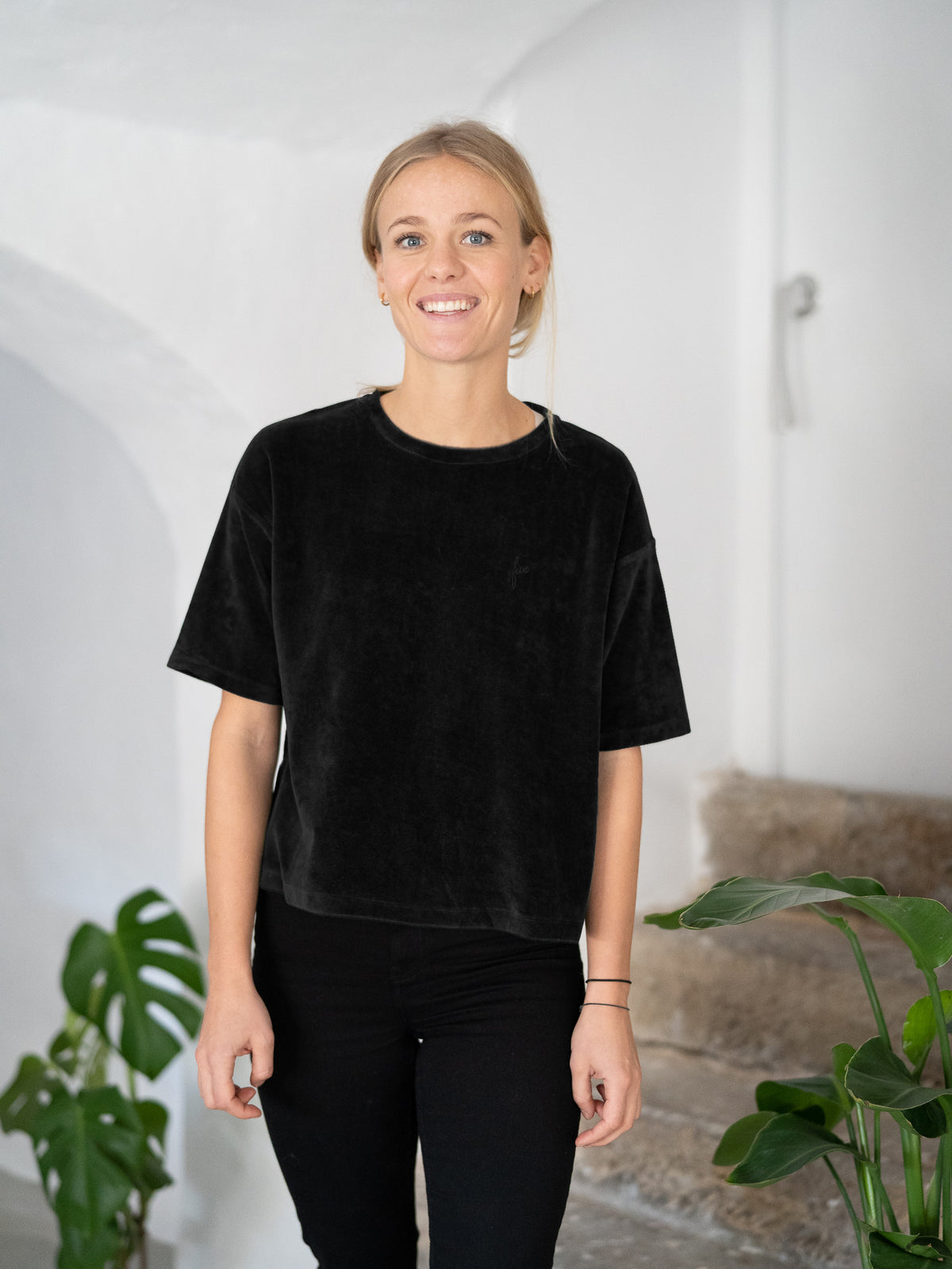 Greta trÀgt das Frauen Cropped Samt T-Shirt in schwarz aus 100% Biobaumwolle