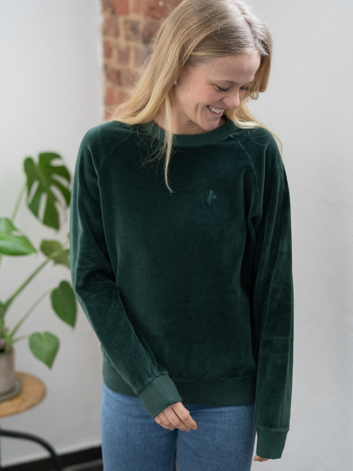 Fair Fashion FUXBAU Frauen Samt Sweater in grĂŒn aus 100% GOTS zertifizierter Biobaumwolle made in Portugal. Getragen von Greta bei uns im LadenbĂŒro in MĂŒnster.