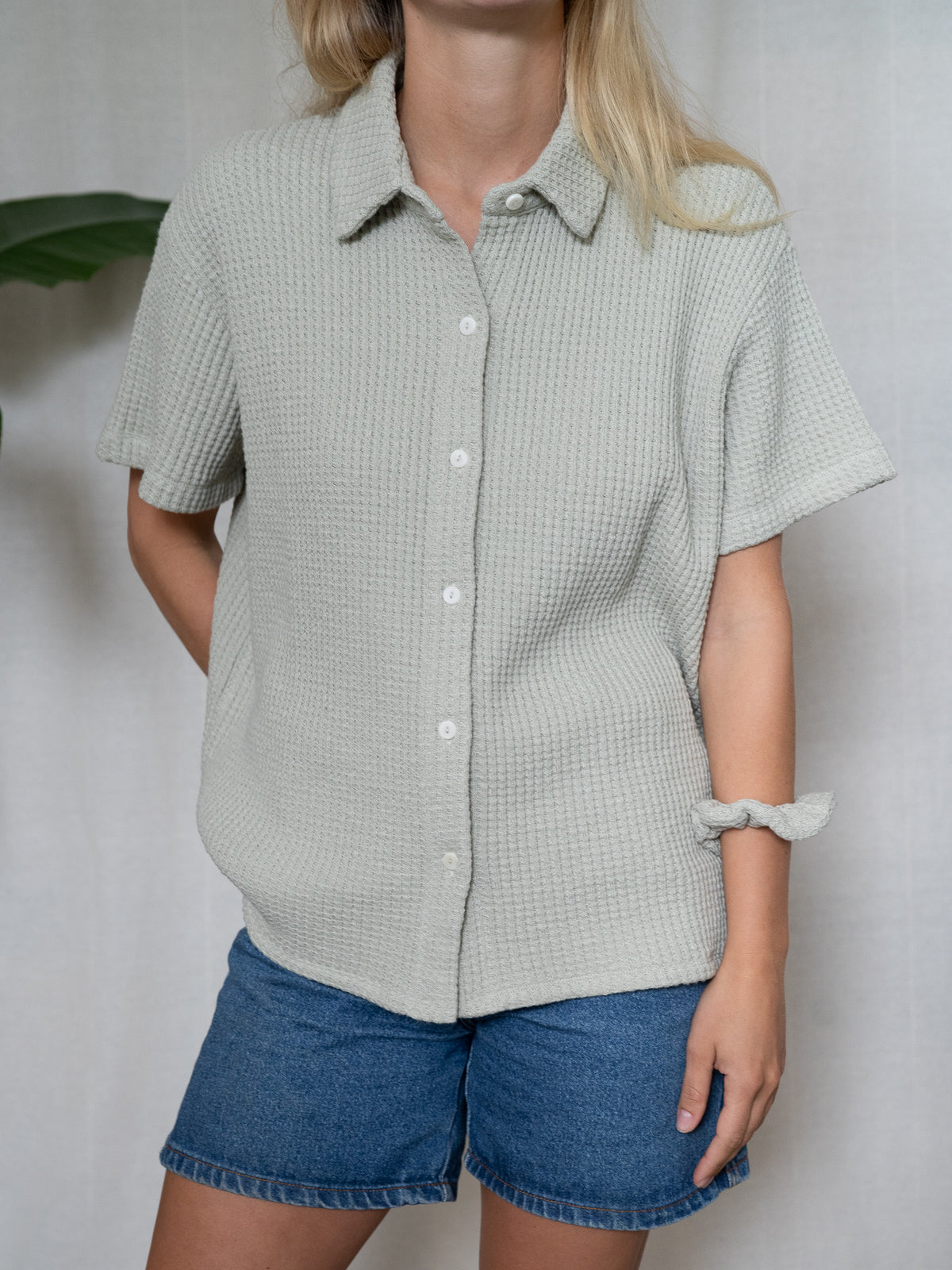 Schlichte Sommerbluse für Damen aus salbeigrünem Waffelstrick – fair fashion Look mit Knopfleiste und kurzem Schnitt