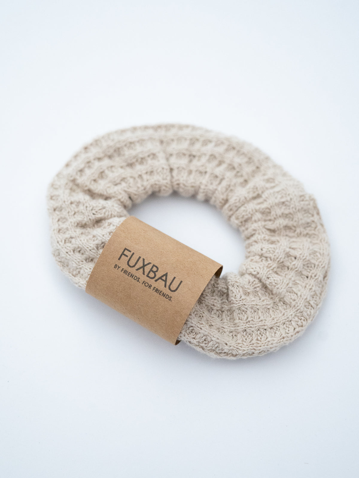 Beiger Scrunchie aus Waffelstrick von FUXBAU â seitliche Ansicht des Haargummis aus fairer Produktion.