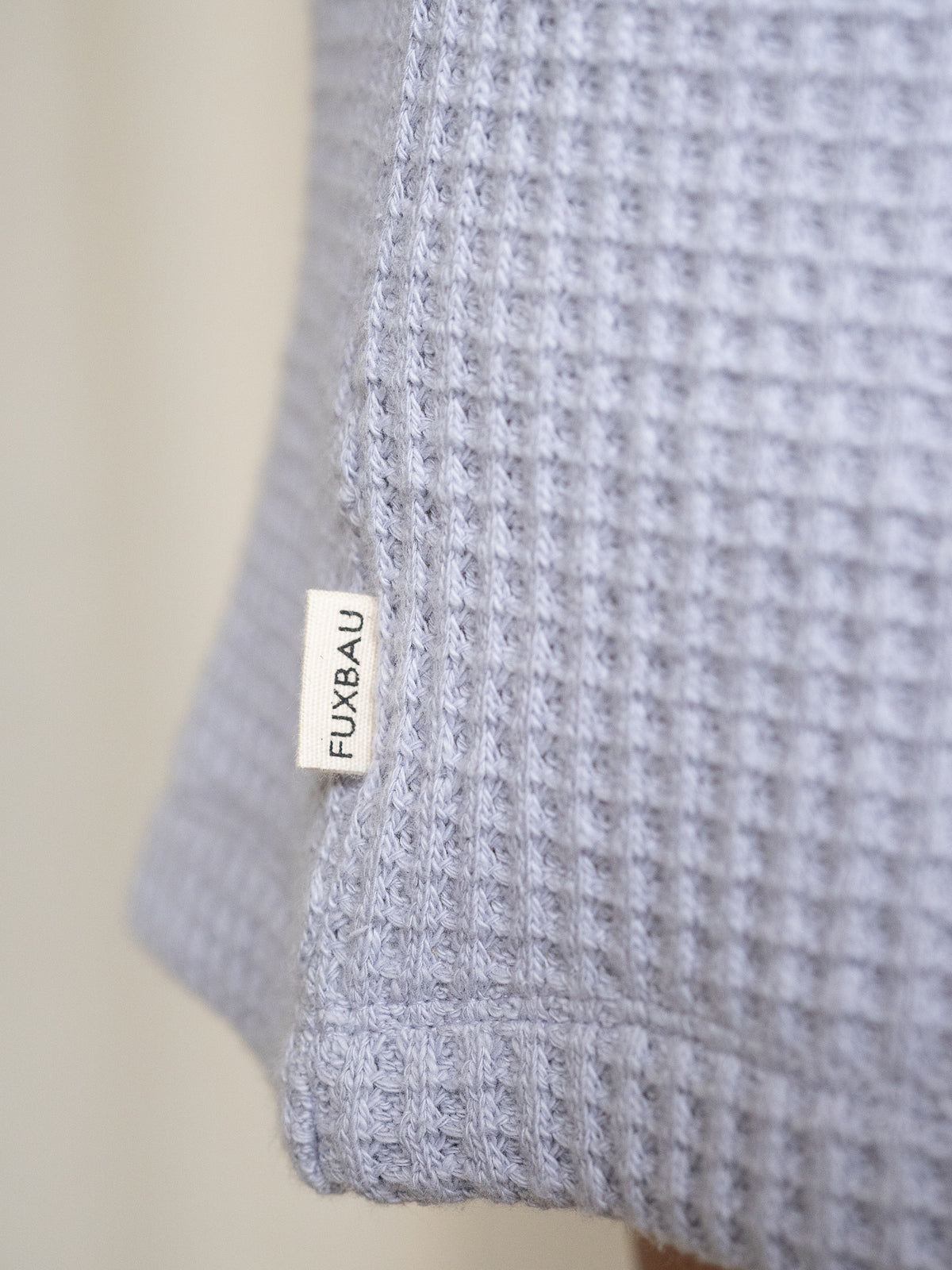 Detailansicht FUXBAU-Label auf den lavendelfarbenen Waffelstrick Shorts â hochwertig verarbeitet aus Bio-Baumwolle