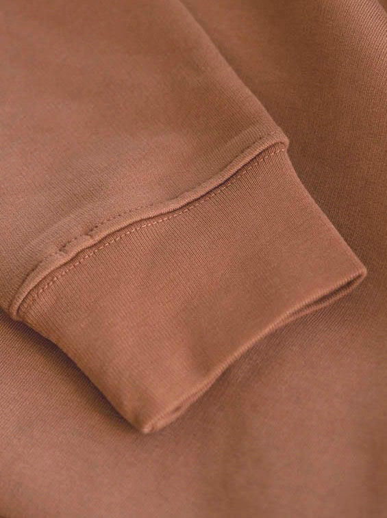 Hochwertige Ărmel in braun eines fair produzierten FUXBAU Hoodies in braun karamell.