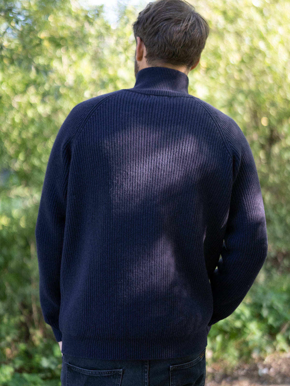 Fair Fashion Männer Merino Troyer in navy aus 100% Merino Schurwolle Made in Italy, getragen von einem jungen Mann der mit dem Rücken zur Kamera steht.