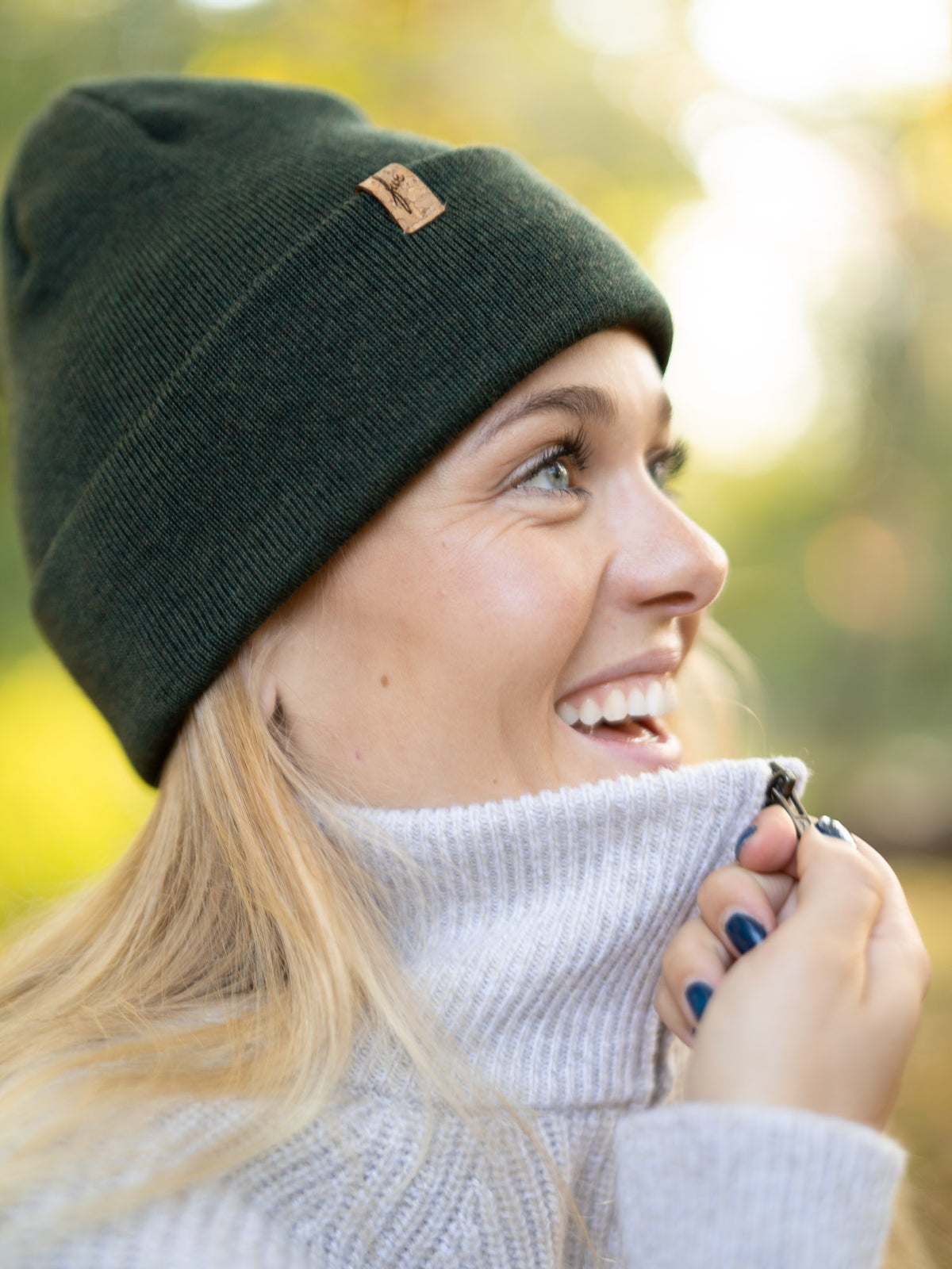 Fair Fashion Merino Kork Beanie in waldgrün von FUXBAU. Getragen von einer jungen, blonden Frau im Herbst in Münster.