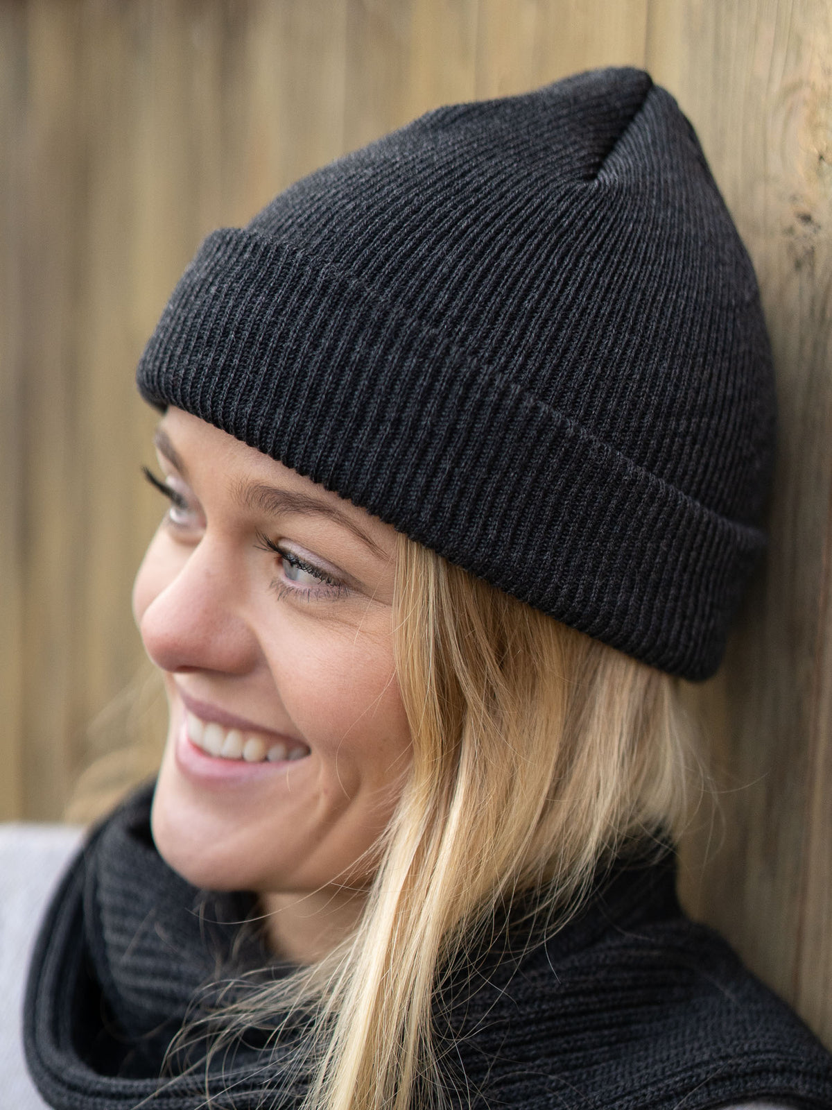 Junge, blonde Frau trägt eine fair gefertigte Strickmütze von FUXBAU aus 100% Merino Schurwolle. GOTS zertifiziert und gestrickt in Deutschland.