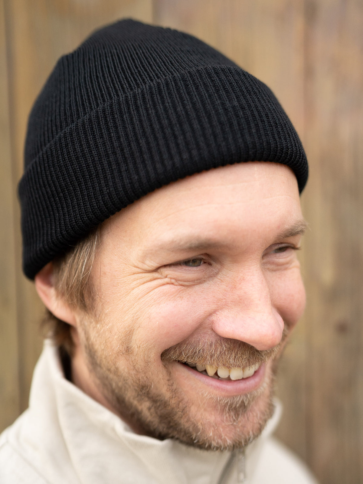 Kenny trägt unsere Merino Strickmütze aus 100% GOTS zertifizierter Schurwolle in schwarz.