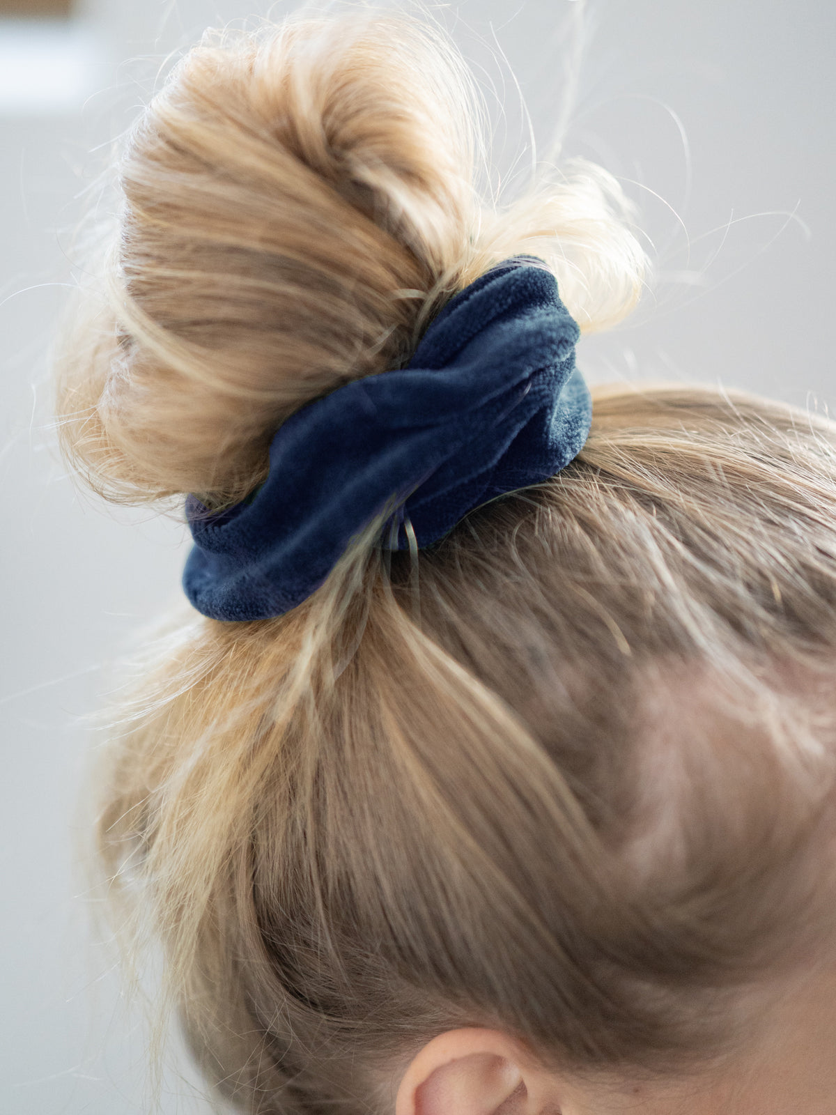 Greta trägt unser faires FUXBAU Scrunchie in navy in den Haaren als Dutt gebunden