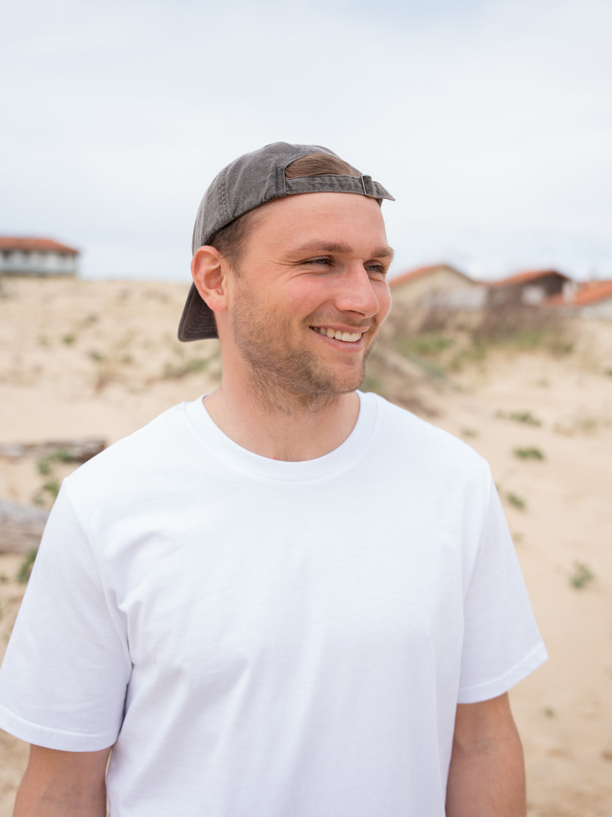 Fredde trÀgt unsere faire Stay Salty Dad Cap in salzschwarz aus 100% GOTS zertifizierter Biobaumwolle Made in Portugal.