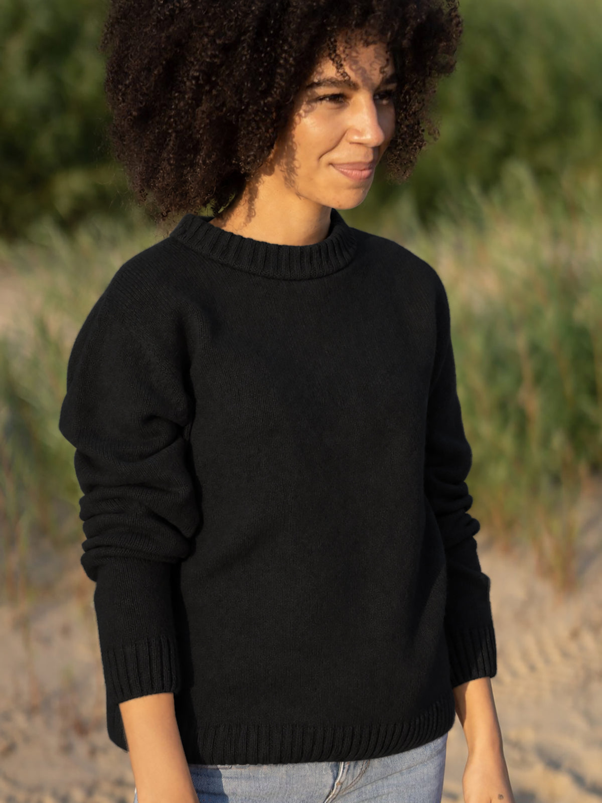 Jacky trÀgt den Strickpullover in schwarz aus 100% Merinowolle und made in Germany.