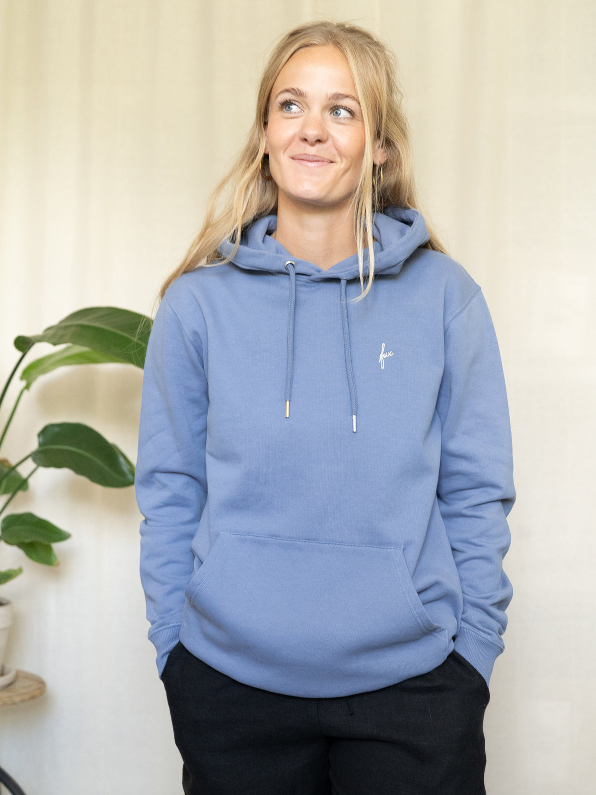 Frontalansicht des himmelblauen Hoodies mit dezenter âfuxâ-Stickerei, getragen von einer Frau.