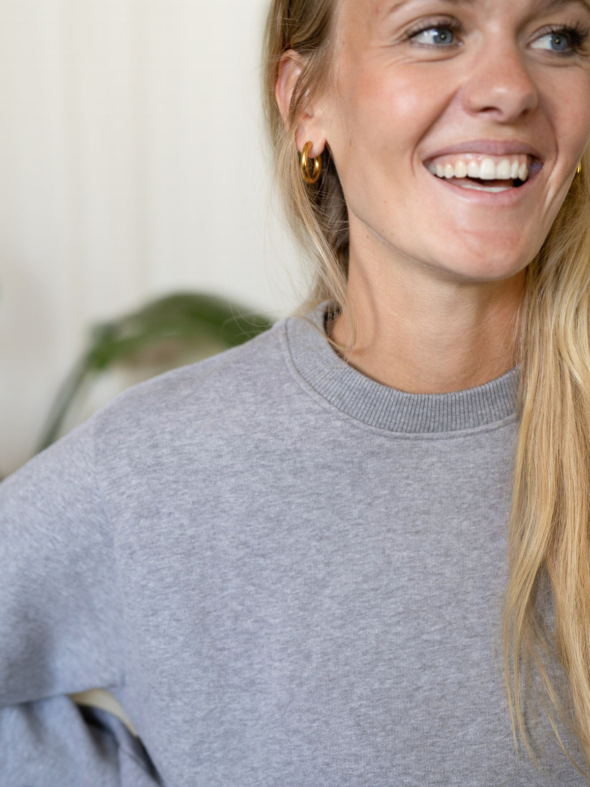 Detailaufnahme Frauen Basic Sweater graumeliert – Modell lächelt, Sweater aus 100% GOTS-zertifizierter Biobaumwolle, fair in Portugal produziert