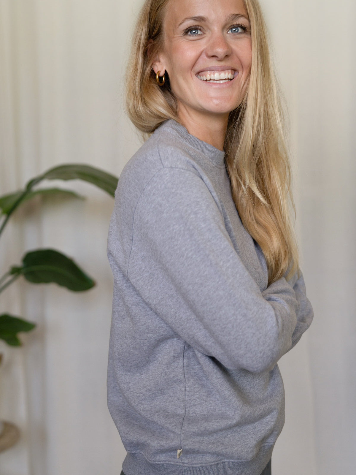 Frauen Basic Sweater graumeliert – Modell lächelt in seitlicher Ansicht, Sweater aus GOTS-zertifizierter Biobaumwolle