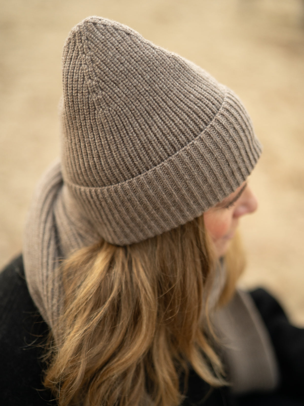 FUXBAU Merino Schal extra lang in braunmeliert â Detailaufnahme getragen, weiche Rippstruktur aus italienischer Merinowolle.