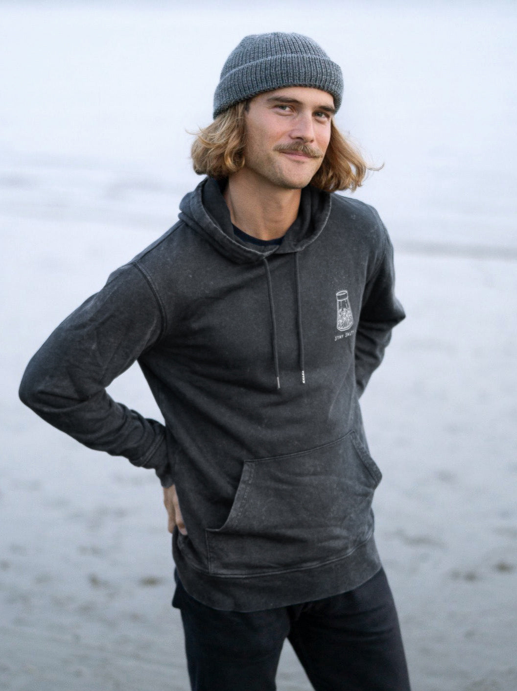 Unser Freund Kelsey trägt unseren FUXBAU Stay Salty Hoodie in salzblau designed by Pia Himmelein aus 100% GOTS zertifizierter Biobaumwolle