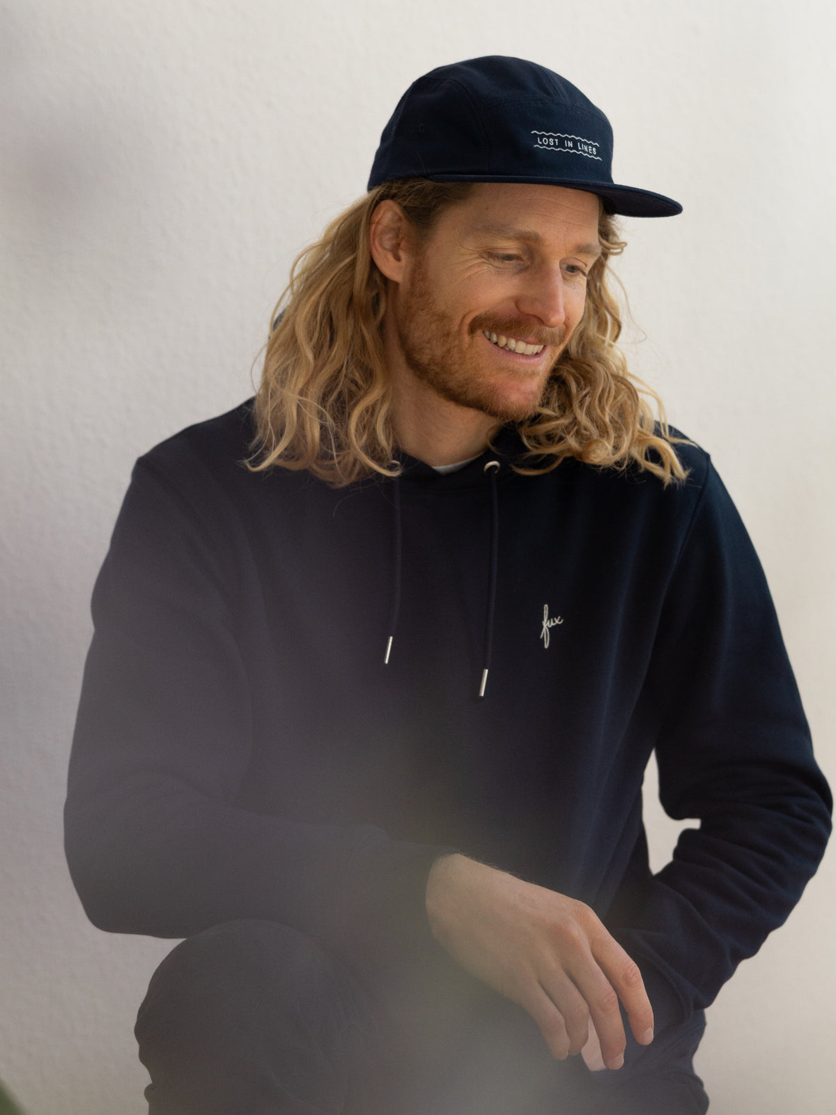 Unisex Hoodie in Navy aus Bio-Baumwolle – fair produziert in Portugal - getragen vom blondem männlichem Modell