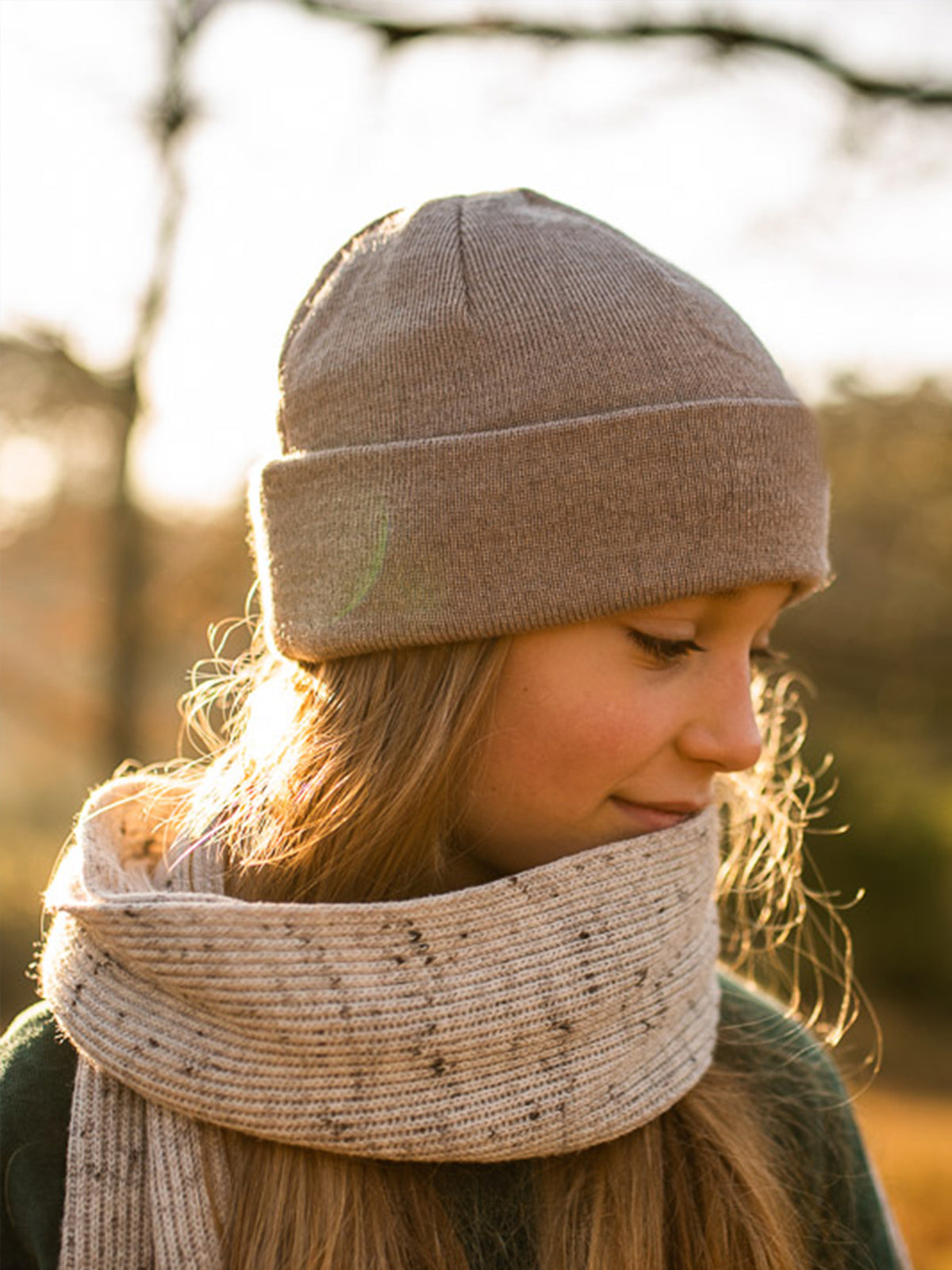 Seitliche Aufnahme eines MĂ€dchens mit sandfarbener FUXBAU Kinder Merino Kork Beanie aus 100% Merinowolle, fair produziert in Deutschland.