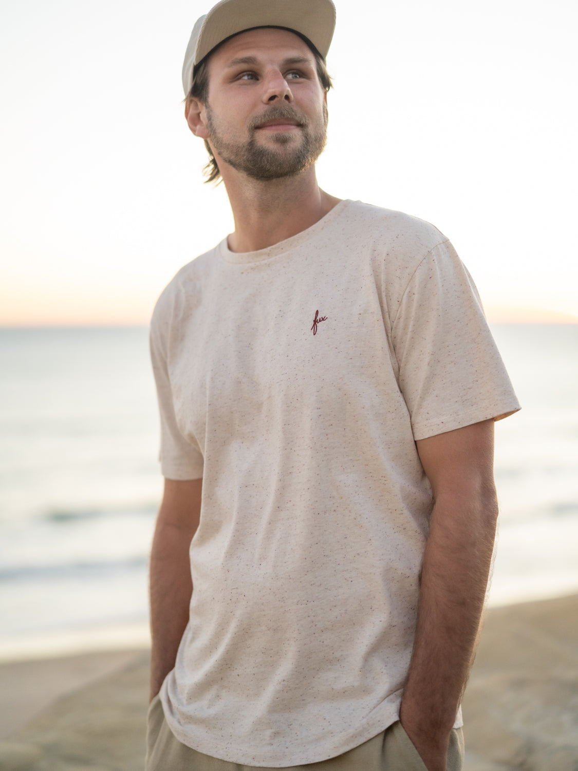 Highlights T-Shirt in creme mit Punkten aus GOTS zertifizierter Biobaumwolle von FUXBAU getragen von Philipp am Strand in Spanien.