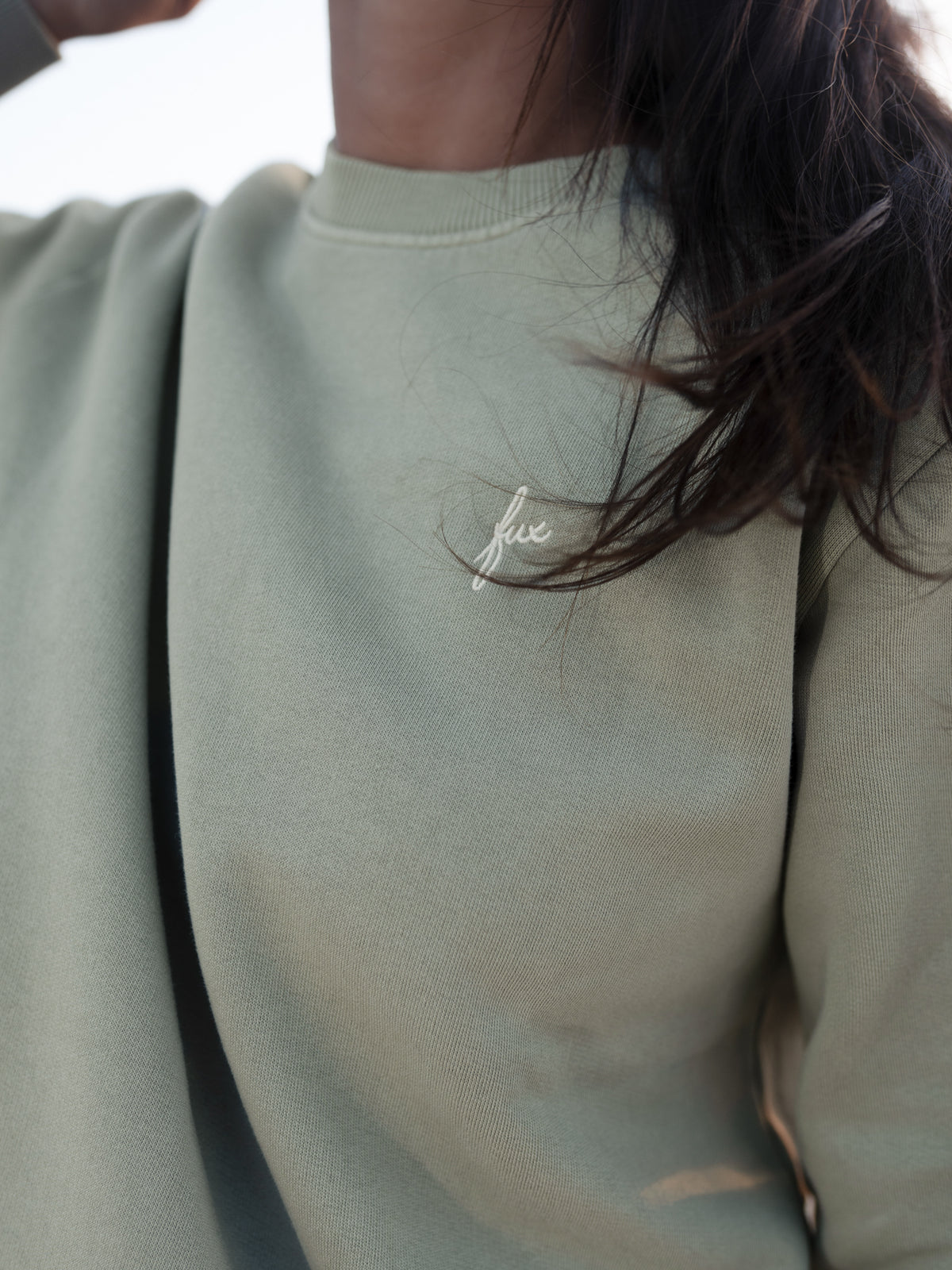 Detailaufnahme vom seegrünen FUXBAU Frauen Pullover aus Biobaumwolle mit dezentem Stick