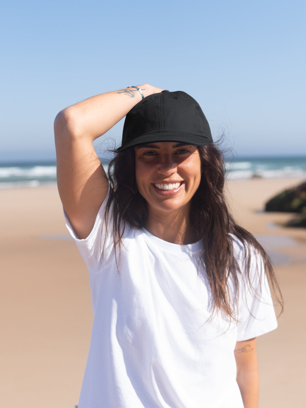 Frau mit schwarzer Unisex Dad Cap am Strand