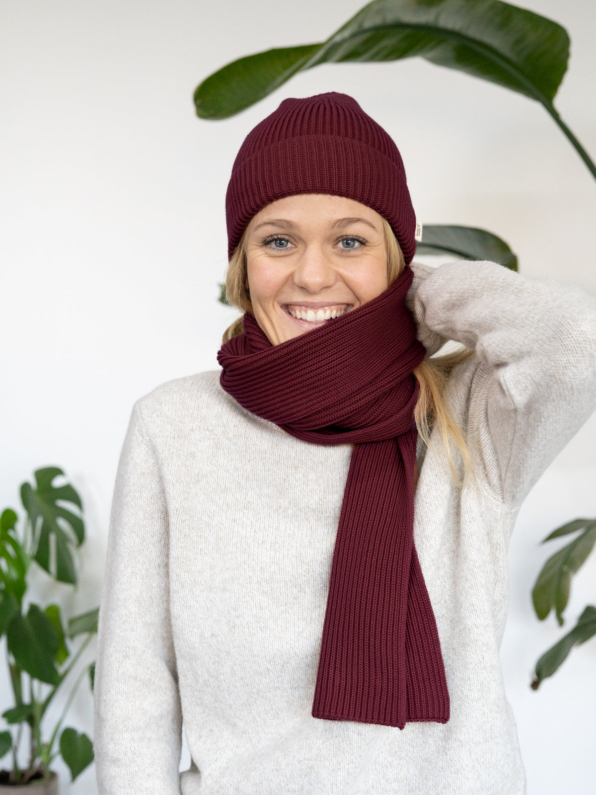Greta trägt die 4Seasons Strickmütze und den Strickschal in Bordeaux aus 100 % Bio-Baumwolle, GOTS-zertifiziert, Made in Italy