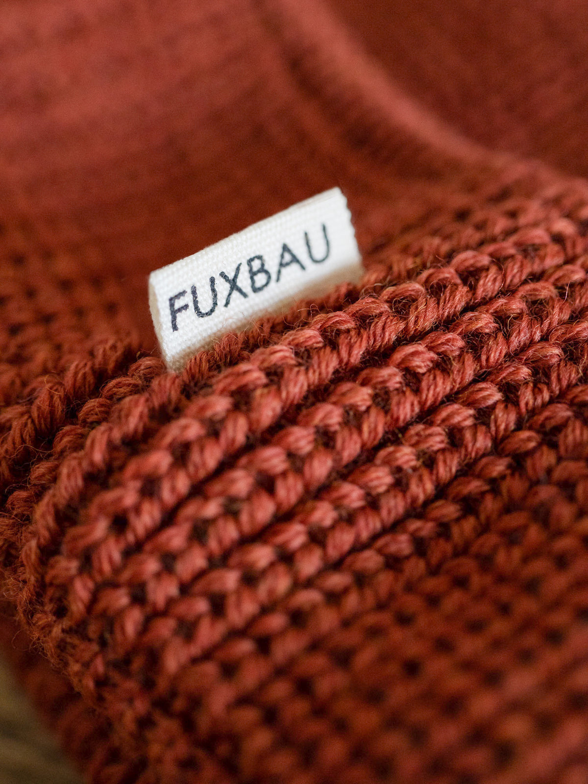 Detailaufnahme der FUXBAU Sideflag der kurzen Merino Fischermütze in herbstorange, GOTS zertifiziert und made in Germany