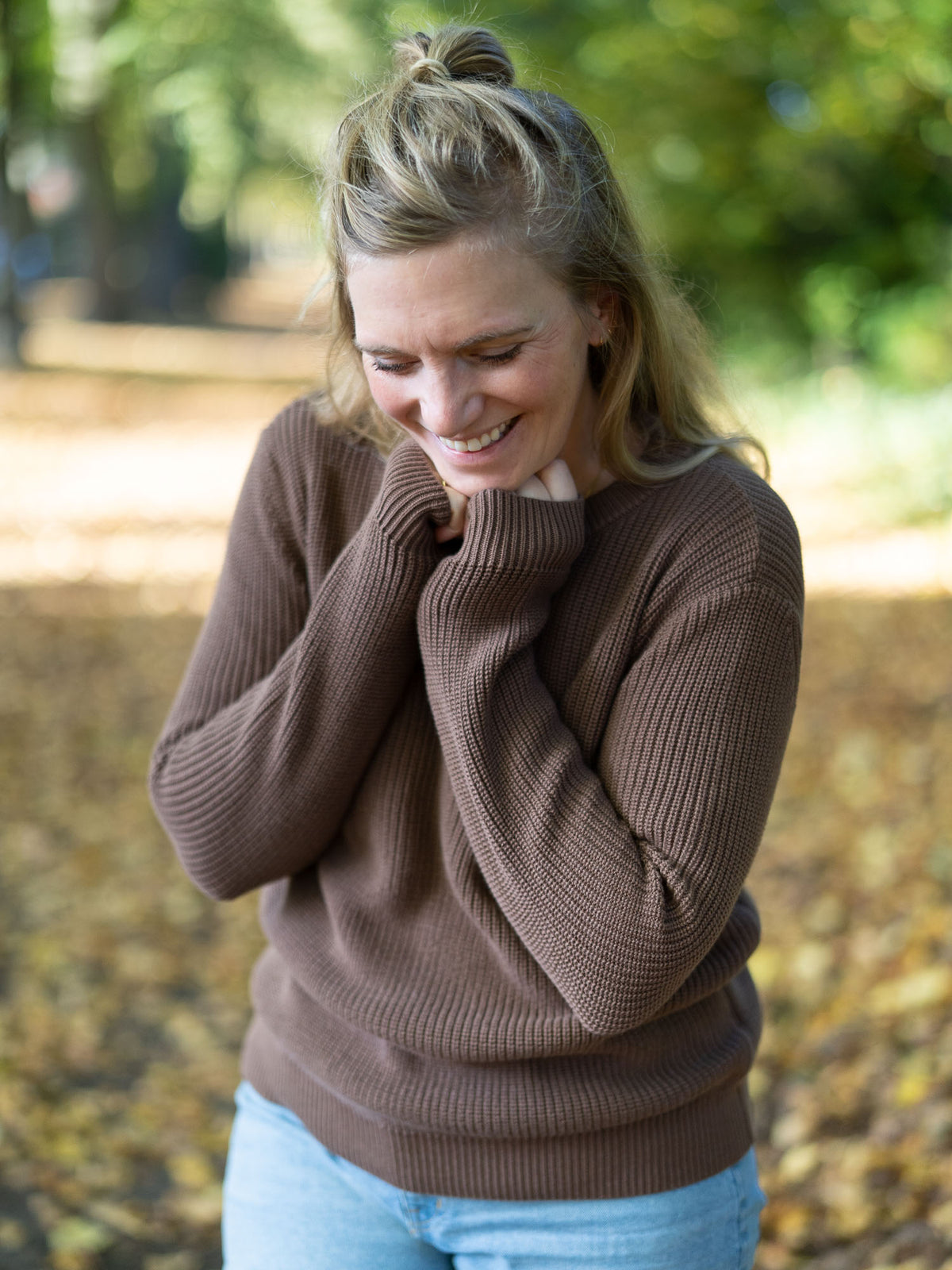 Fair Fashion 4Seasons Strickpullover aus 100% GOTS zertifizierter Biobaumwolle in braun. Getragen von einer jungen blonden Frau im Herbst.