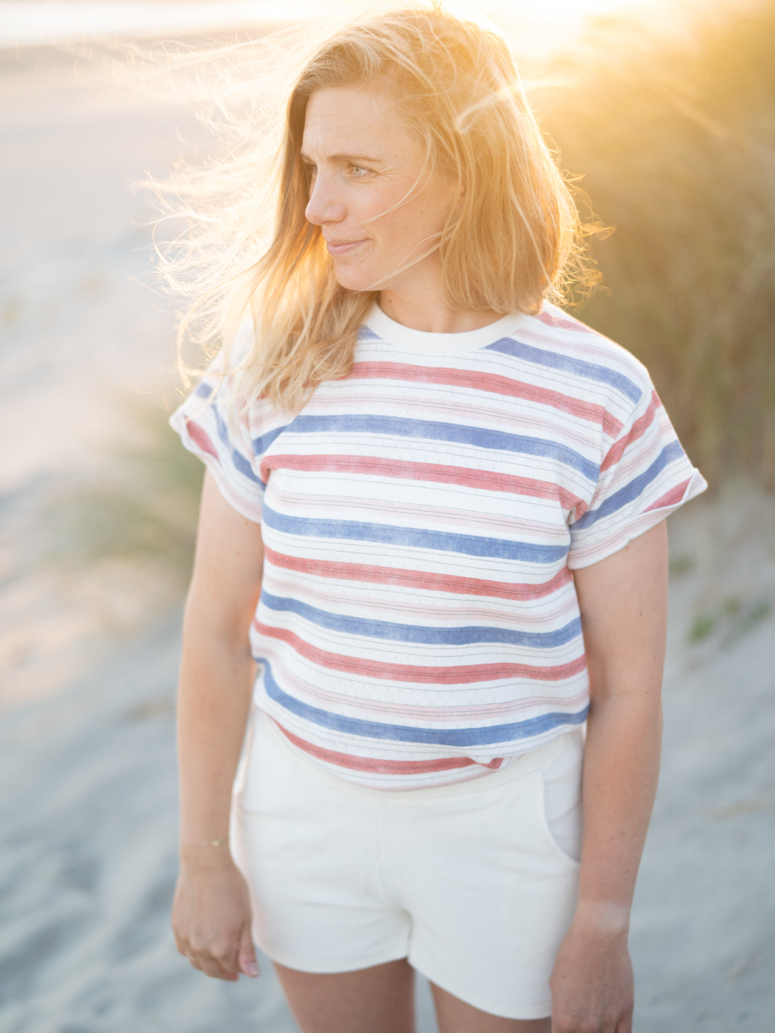 Frauen Ajour Streifenshirt in weiß blau & rot aus 100% Biobaumwolle made in Portugal getragen von Isi am Stand in Portugal.