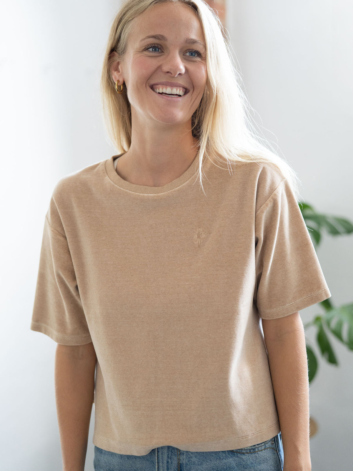 Greta trägt das faire Frauen Cropped Samt T-Shirt in beige gelb geriffelt von FUXBAU aus 100% Biobaumwolle
