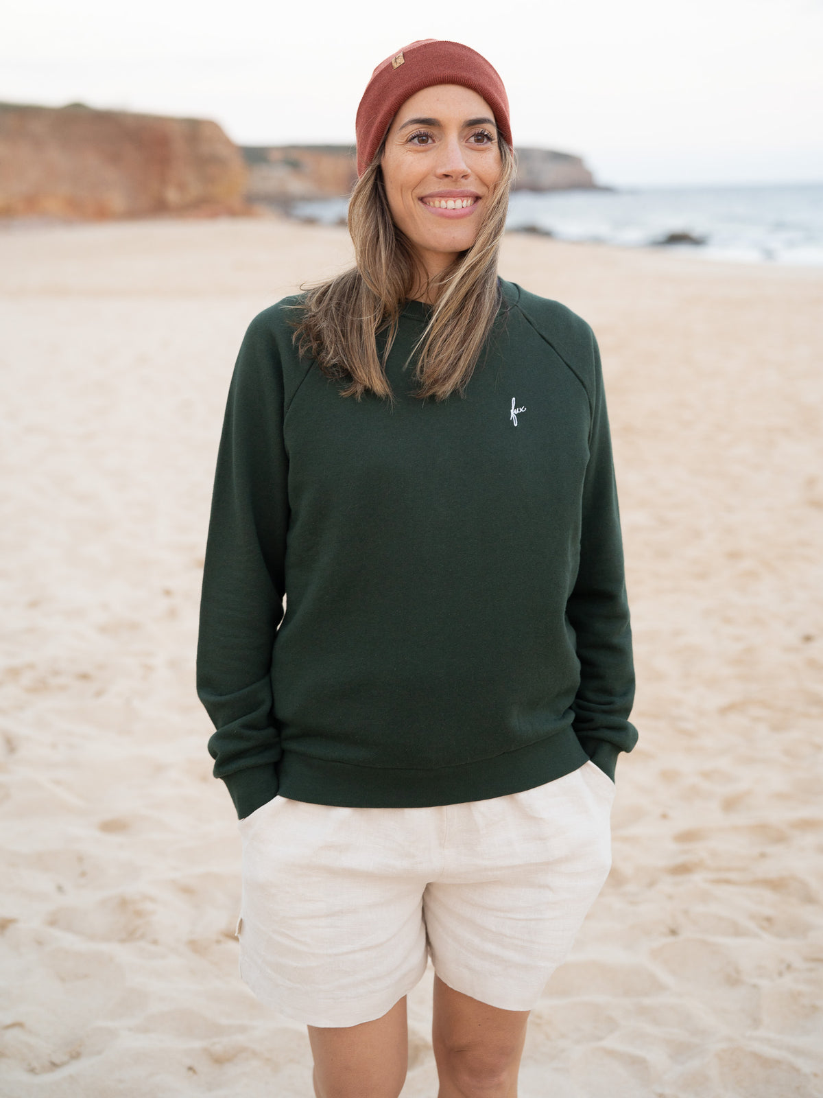 Fair Fashion Frauen Leinenshorts in cremeweiss von FUXBAU Made in Portugal aus 100% Leinen getragen am Strand in Portugal.