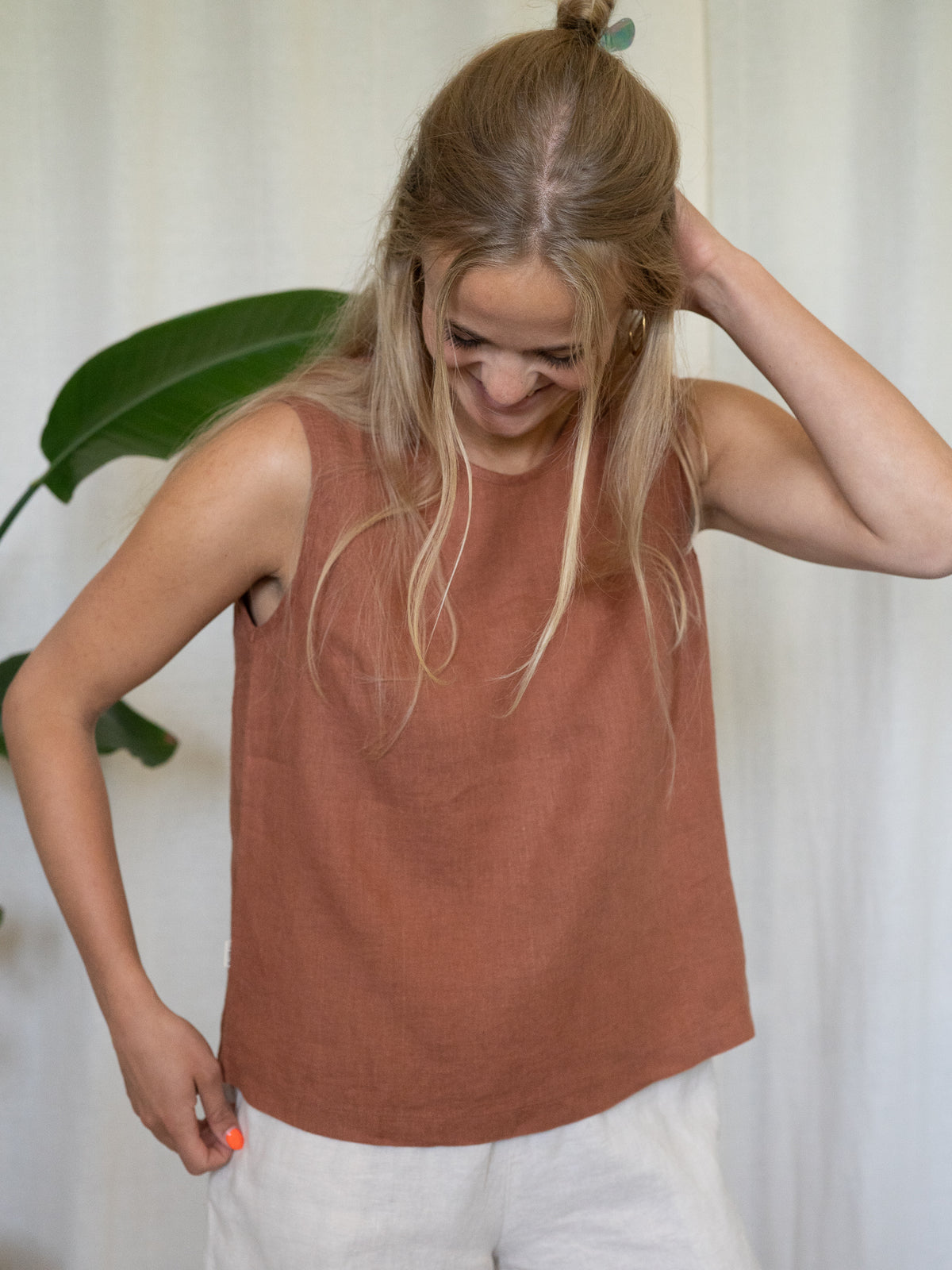 Frau trägt ärmelloses Leinentop in Rostbraun – Sommermode aus 100% Leinen von FUXBAU, fair produziert in Europa, perfekt für heiße Tage