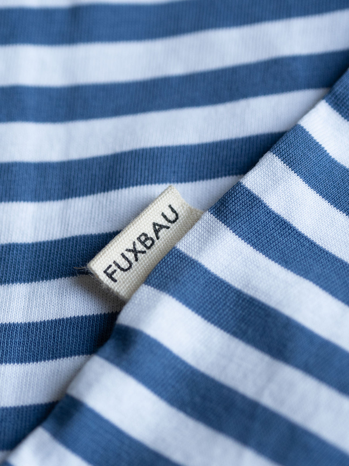 Detailansicht einer FUXBAU Sideflag bei einem blau weiss gestreiften Frauen T-Shirts aus Biobaumwolle von FUXBAU. 