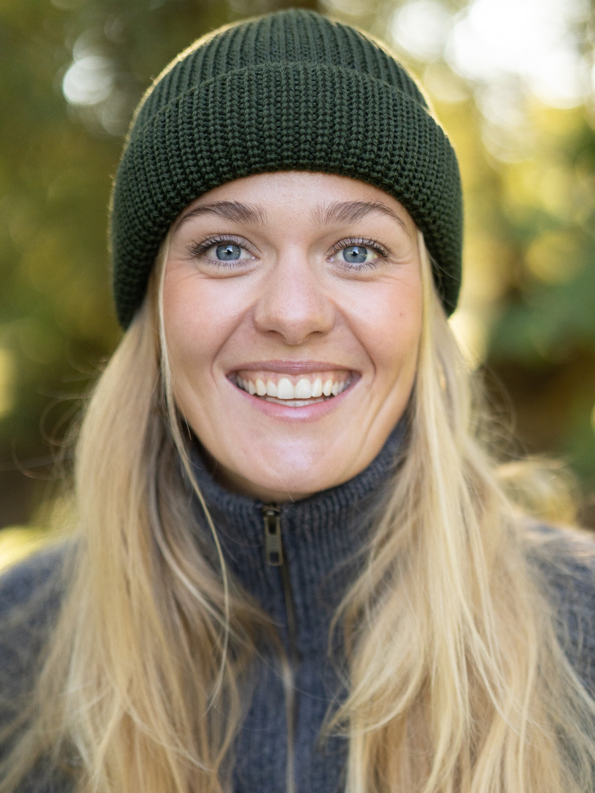 Frau mit waldgrüner FUXBAU Merino Fischermütze – fair produzierte Strickmütze Made in Germany im minimalistischen Design