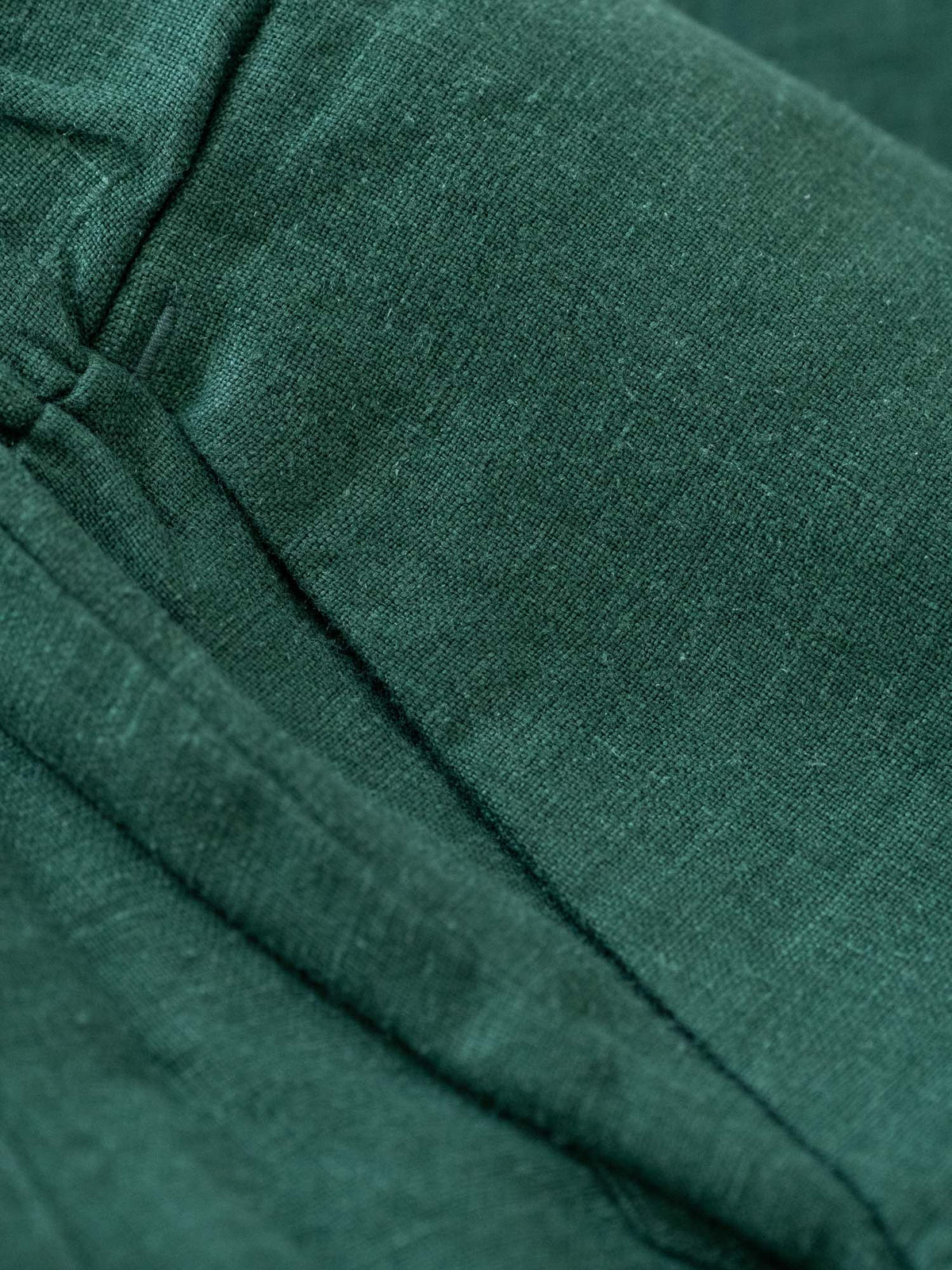 Detailbild einer Hosentasche der FUXBAU Leinenkollektion in grün