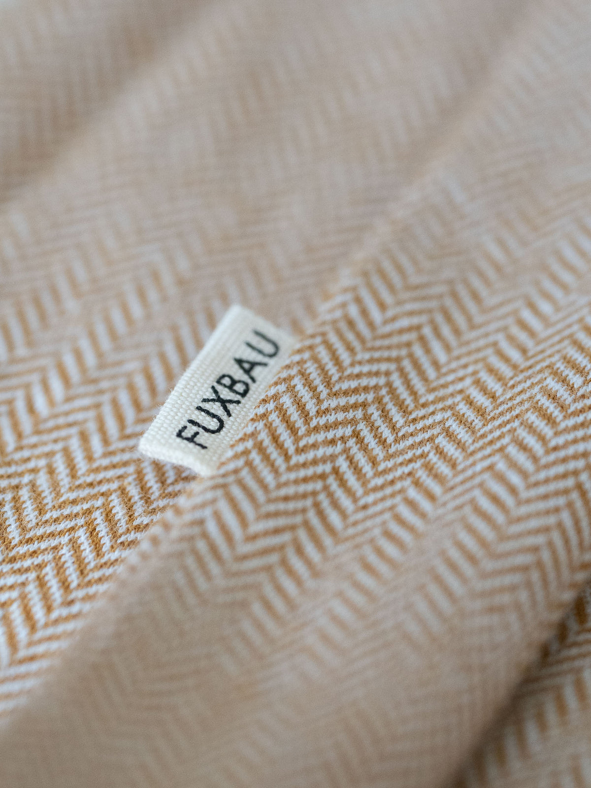 Detailaufnahme eines Männer Hemd von FUXBAU in senfgelb und einem Fishbone Muster aus 100% Biobaumwolle.