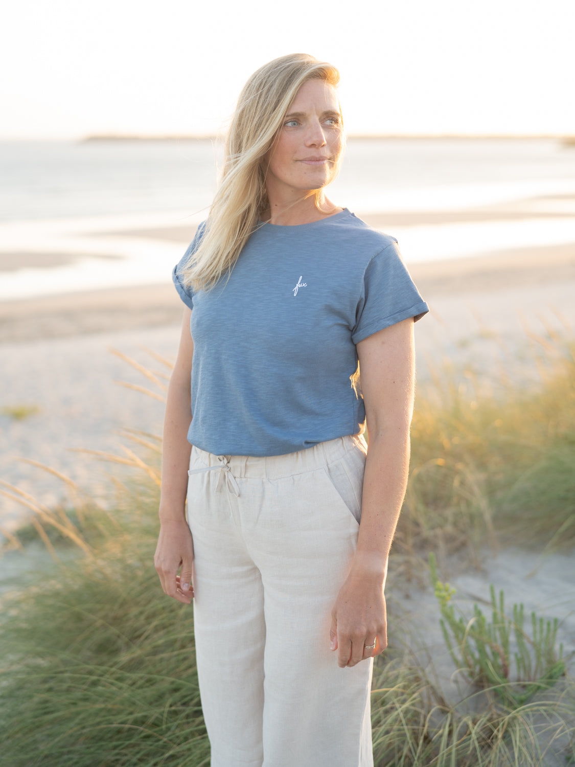 Isi trägt das FUXBAU Frauen fux Azul T-Shirt in blau meliert am Meer.