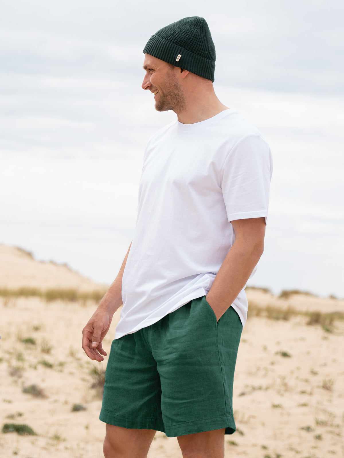 Fredde ist 1,85m und trägt "L" in der fairen FUXBAU Männer Leinenshorts in grün.